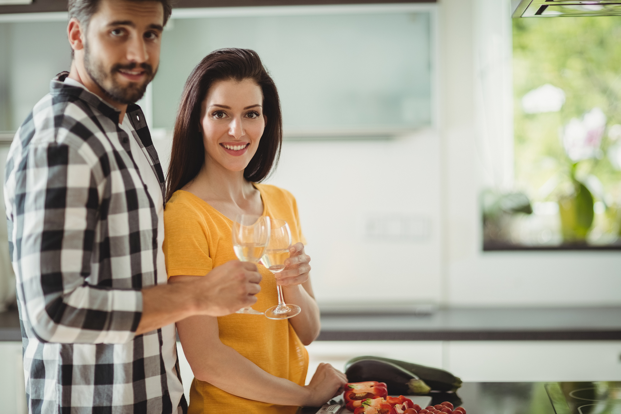 happy couple toasting glasses of champagne while chopping vegeta