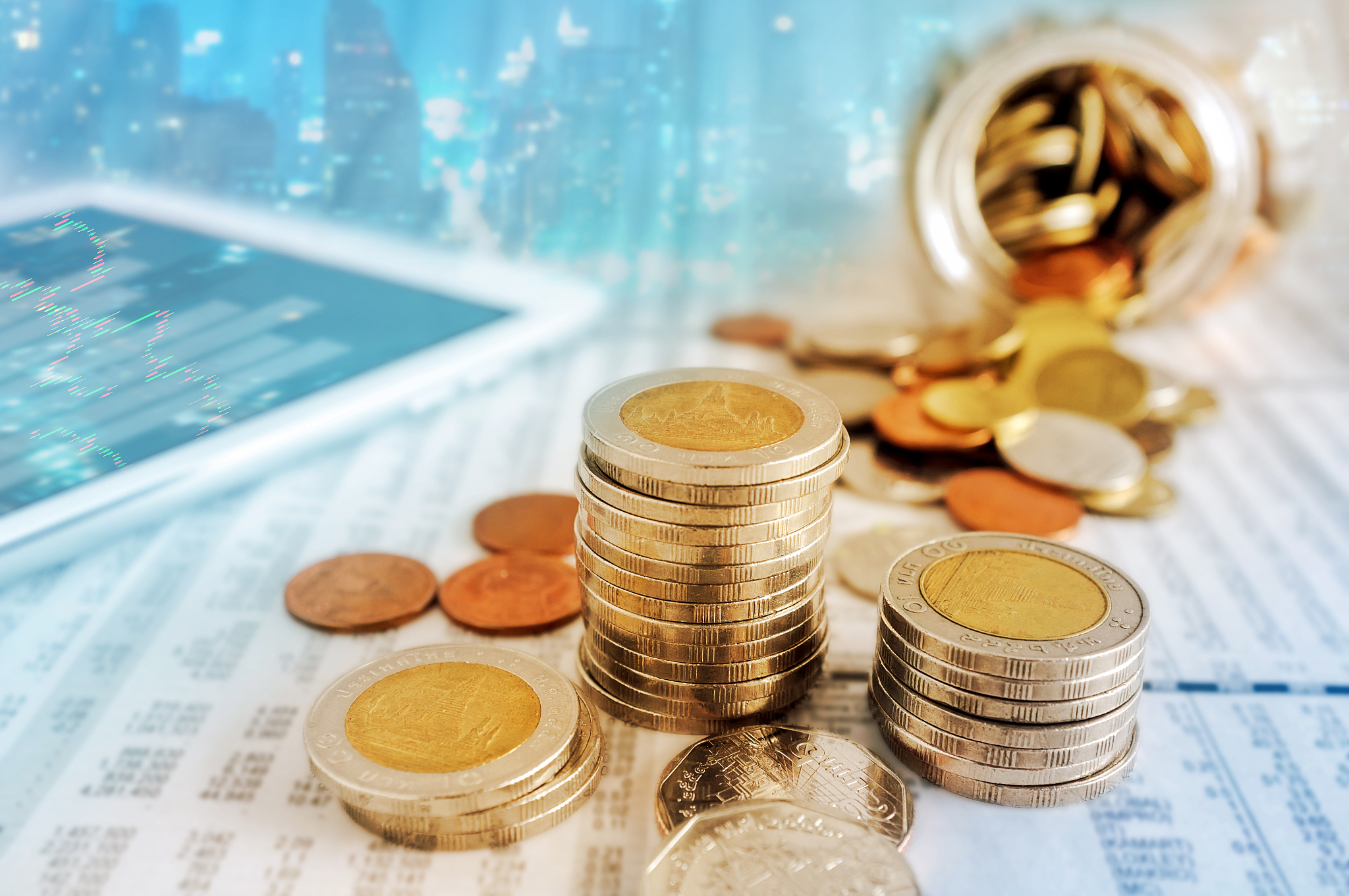 business concept, coin stacks and tablet on news paper.