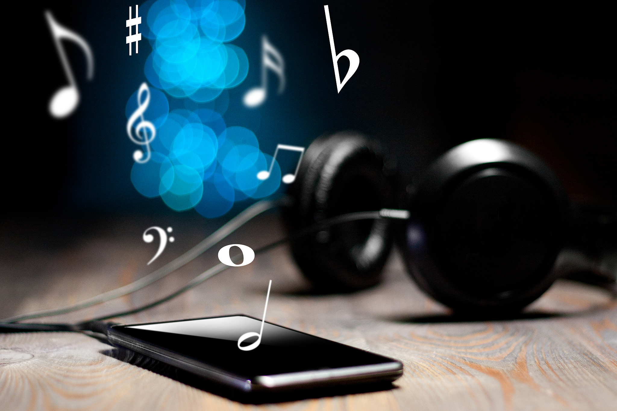 close-up of headphones connected to a smart phone on a wooden ba