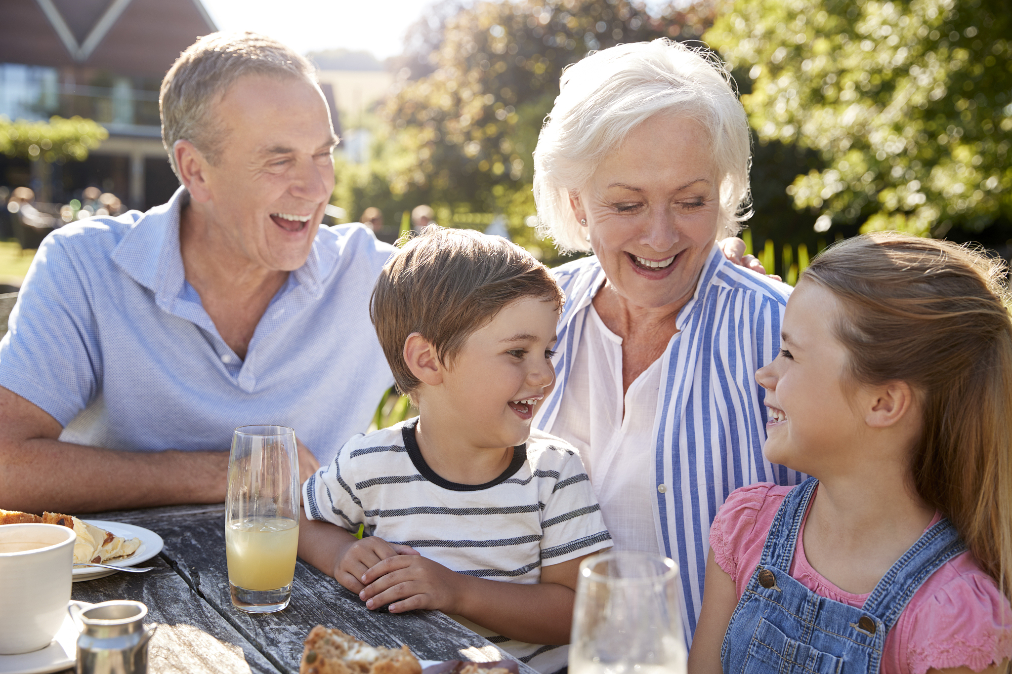 grandparents with grandchildren enjoying outdoor summer snack at