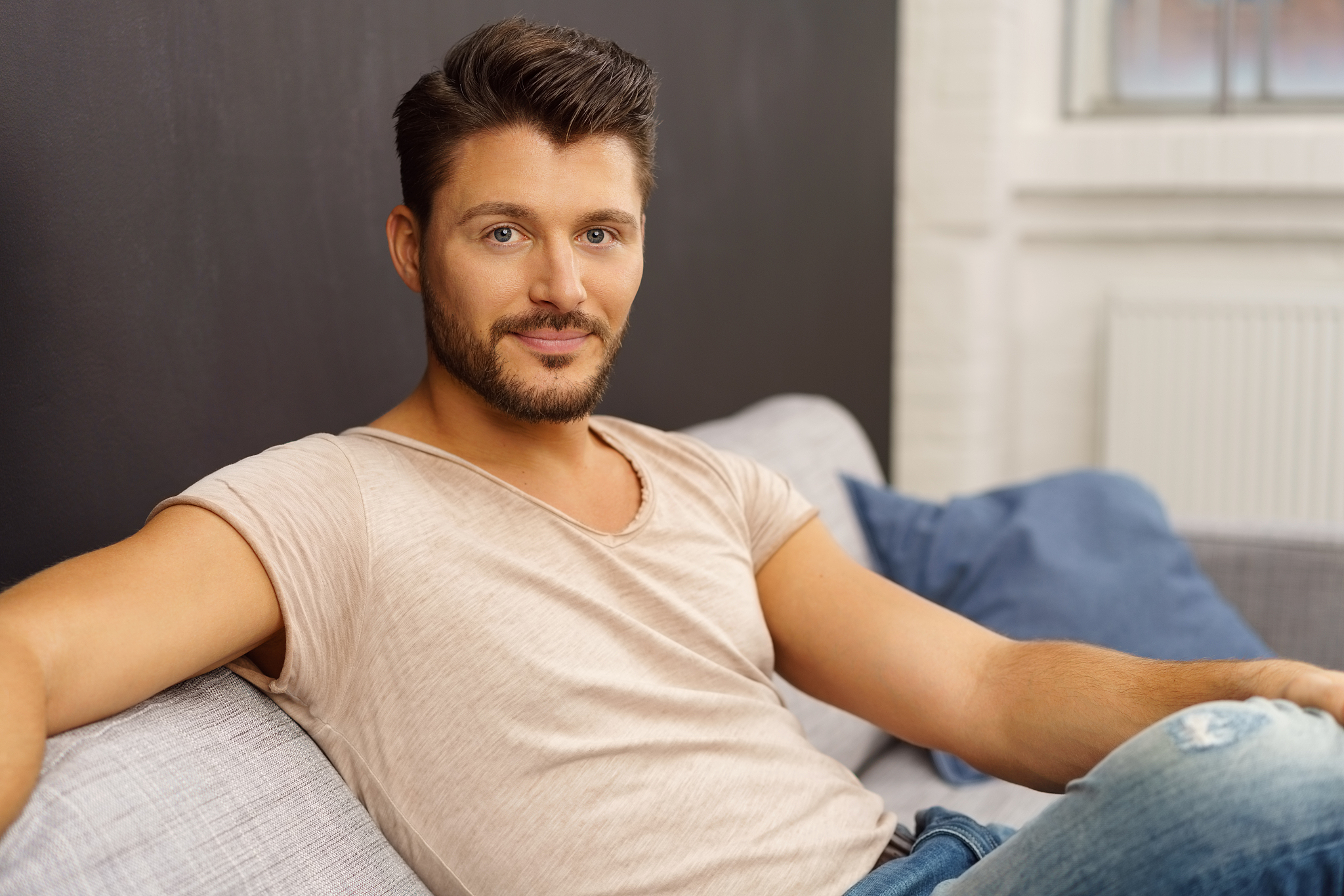 attractive sexy man relaxing at home on a sofa