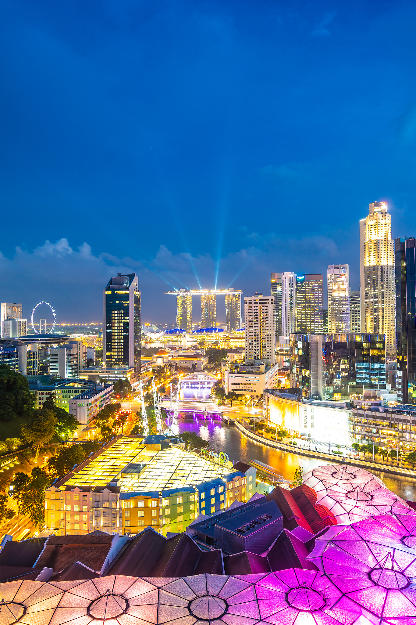 illuminated buildings against blue sky at night