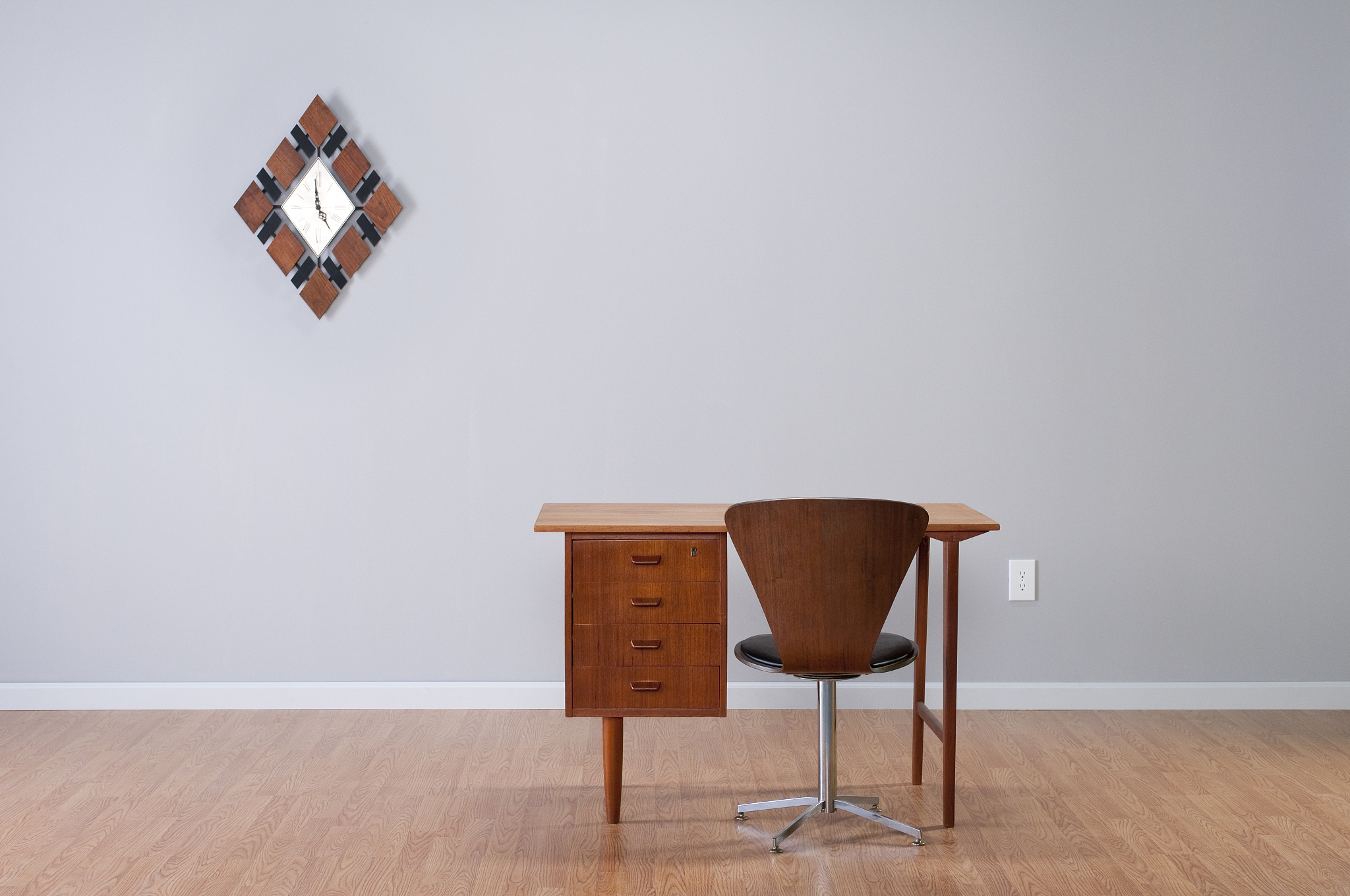 danish desk and clock in empty room.