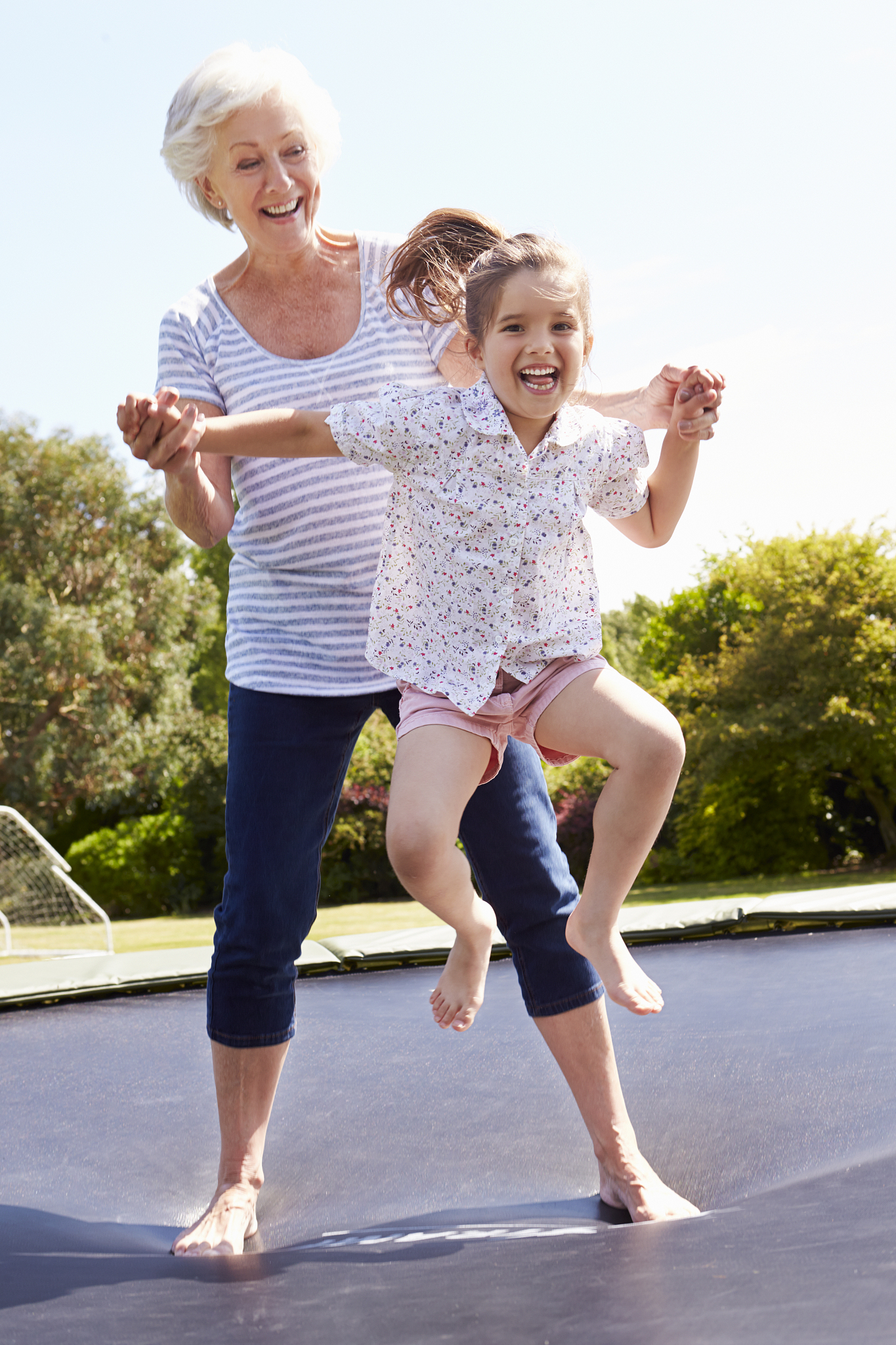grandmother and granddaughter bouncing on trampoline