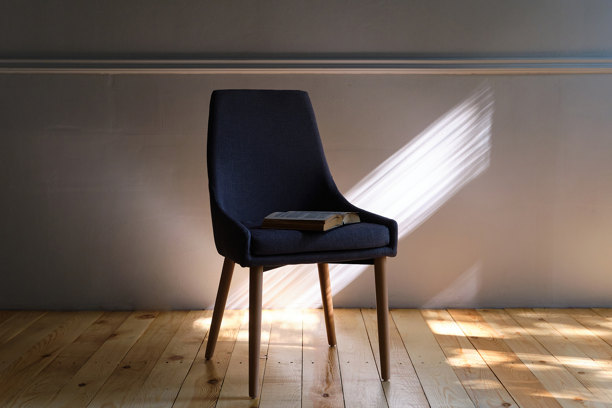 interior of the living room with a blue armchair near a light wa
