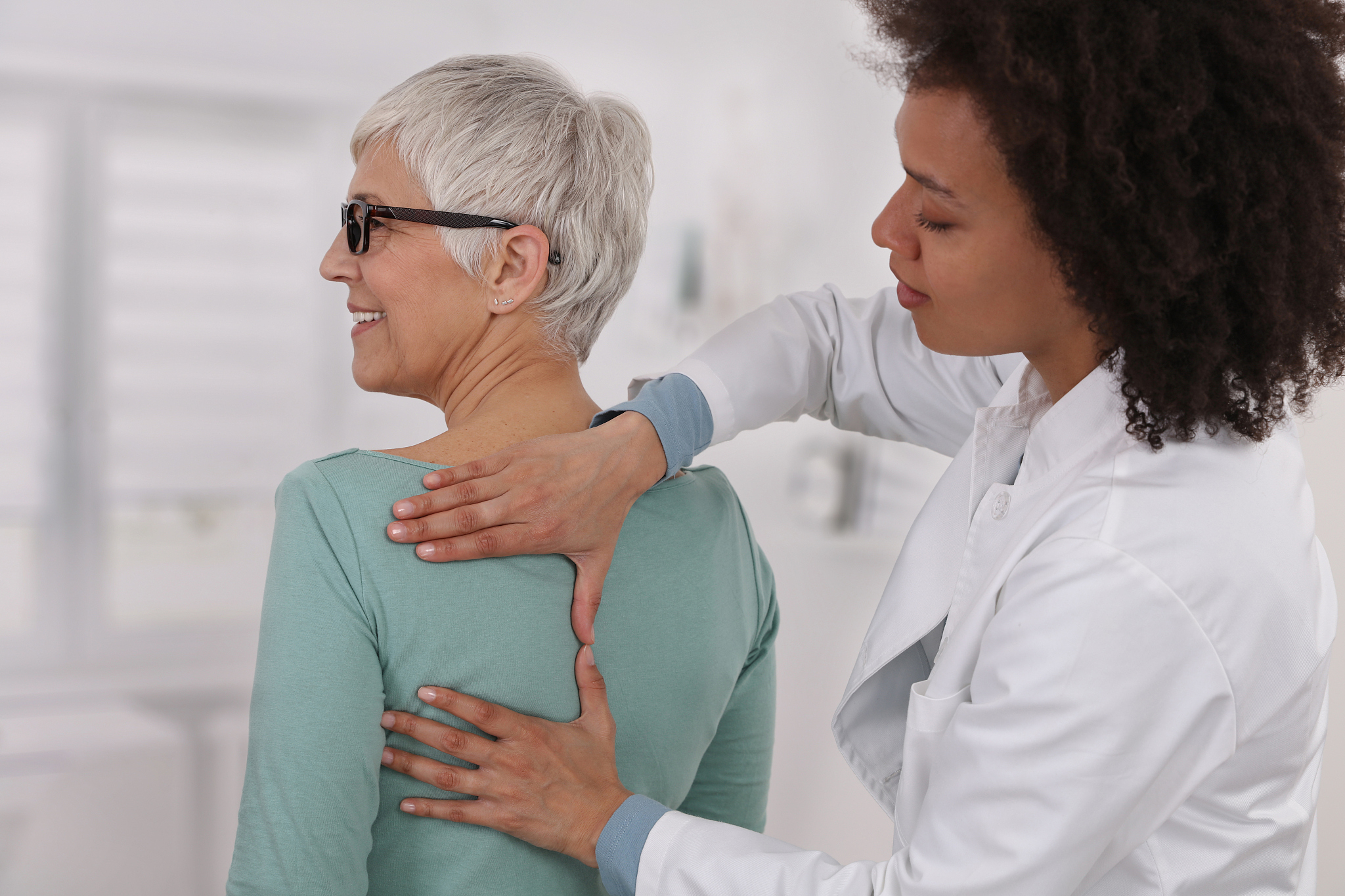 mature woman having chiropractic back adjustment. osteopathy, ph