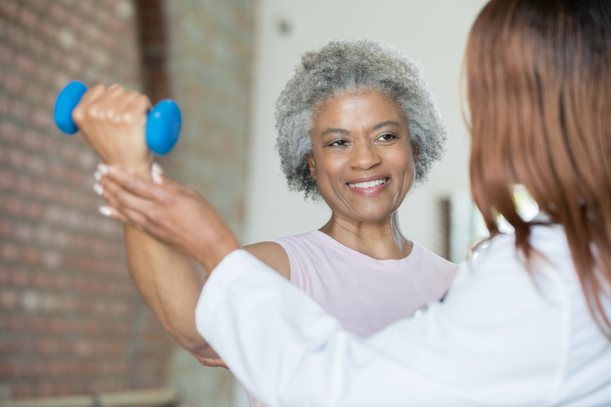 senior female smiling at physical therapist