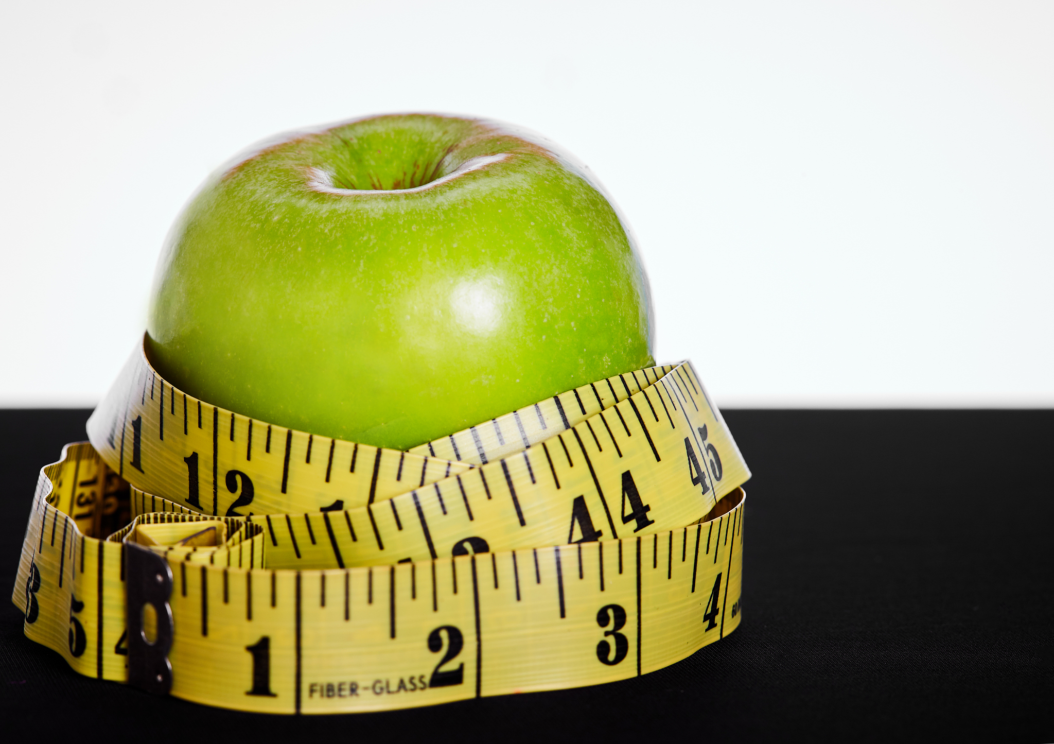 apple wrapped in tape measure