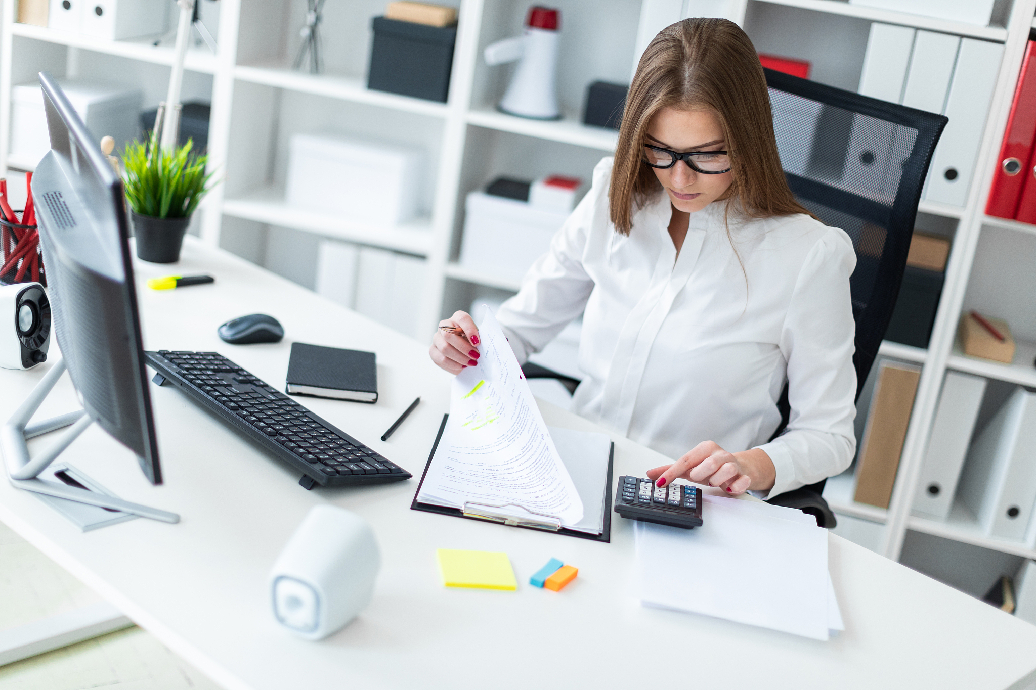 young girl sitting at the table and working with a computer, doc