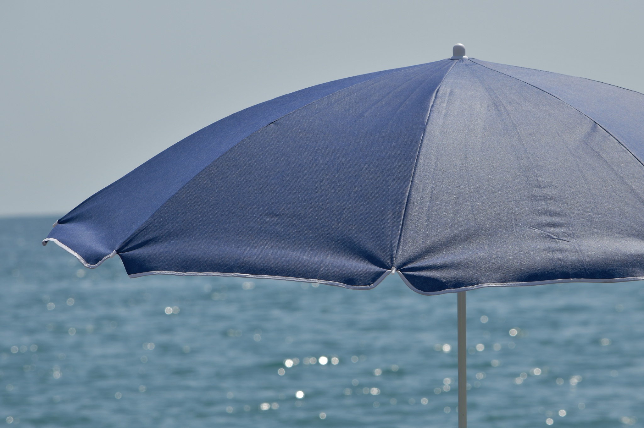an open sun umbrella awning against the sea.