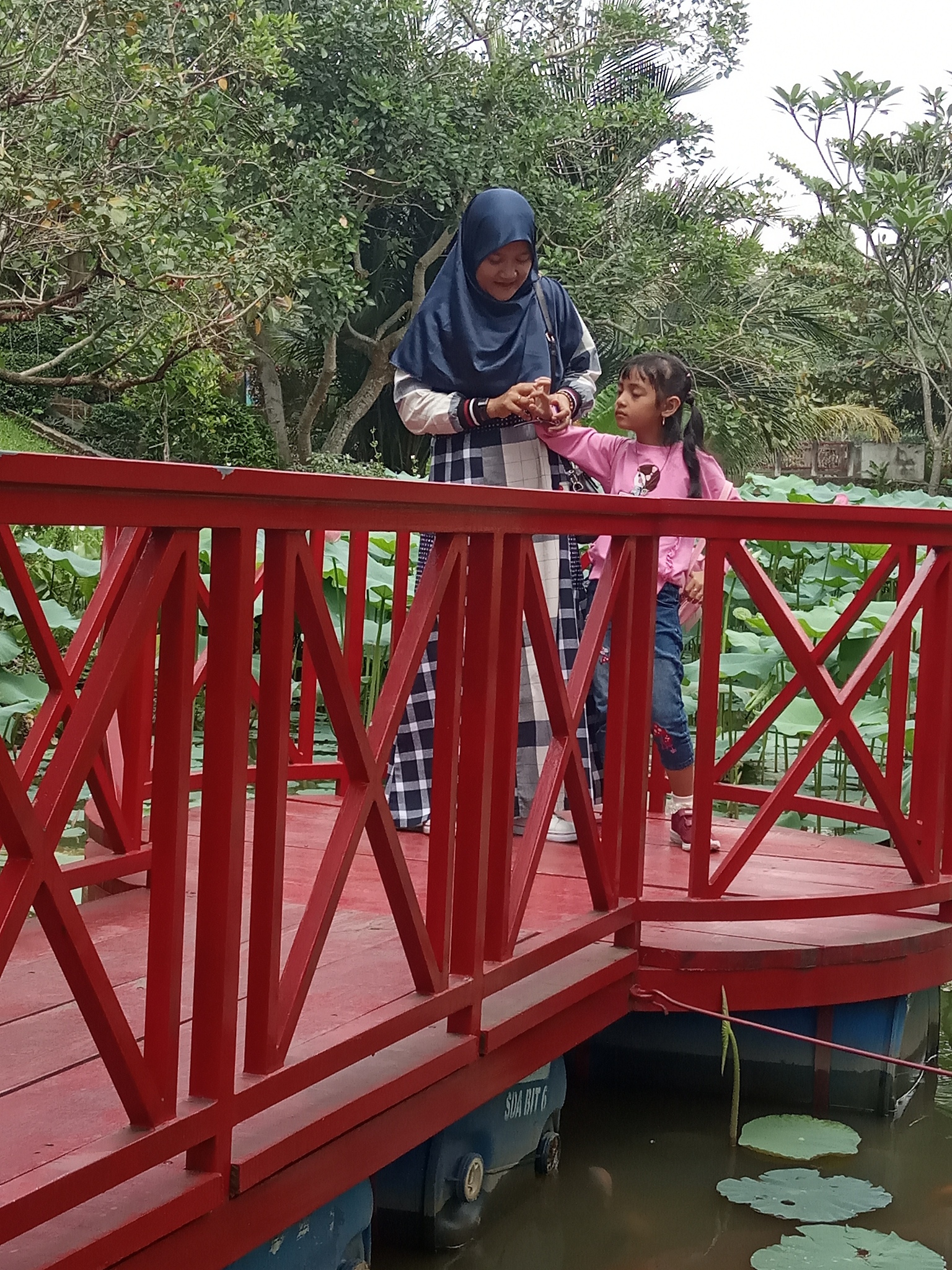people standing on footbridge