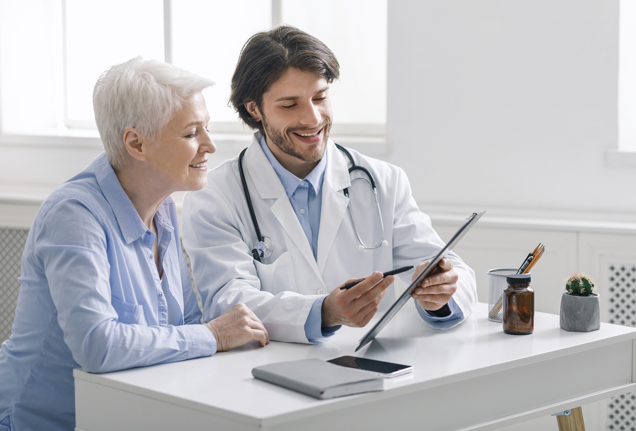 doctor showing analysis results to senior patient