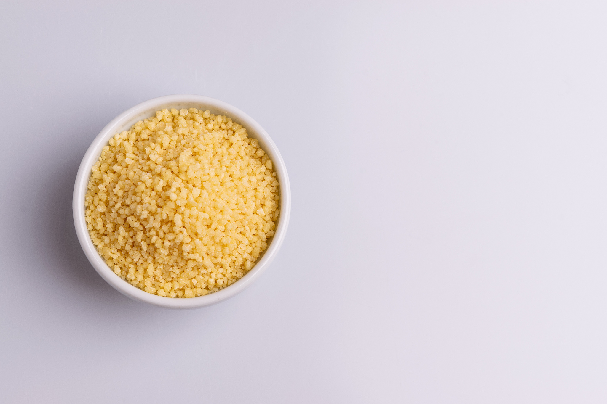 dry couscous isolated on white background, soft light, copy spac