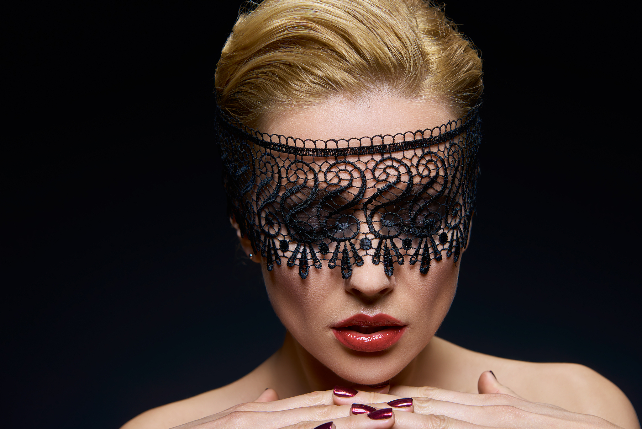 creative portrait of a young woman in a lace mask.