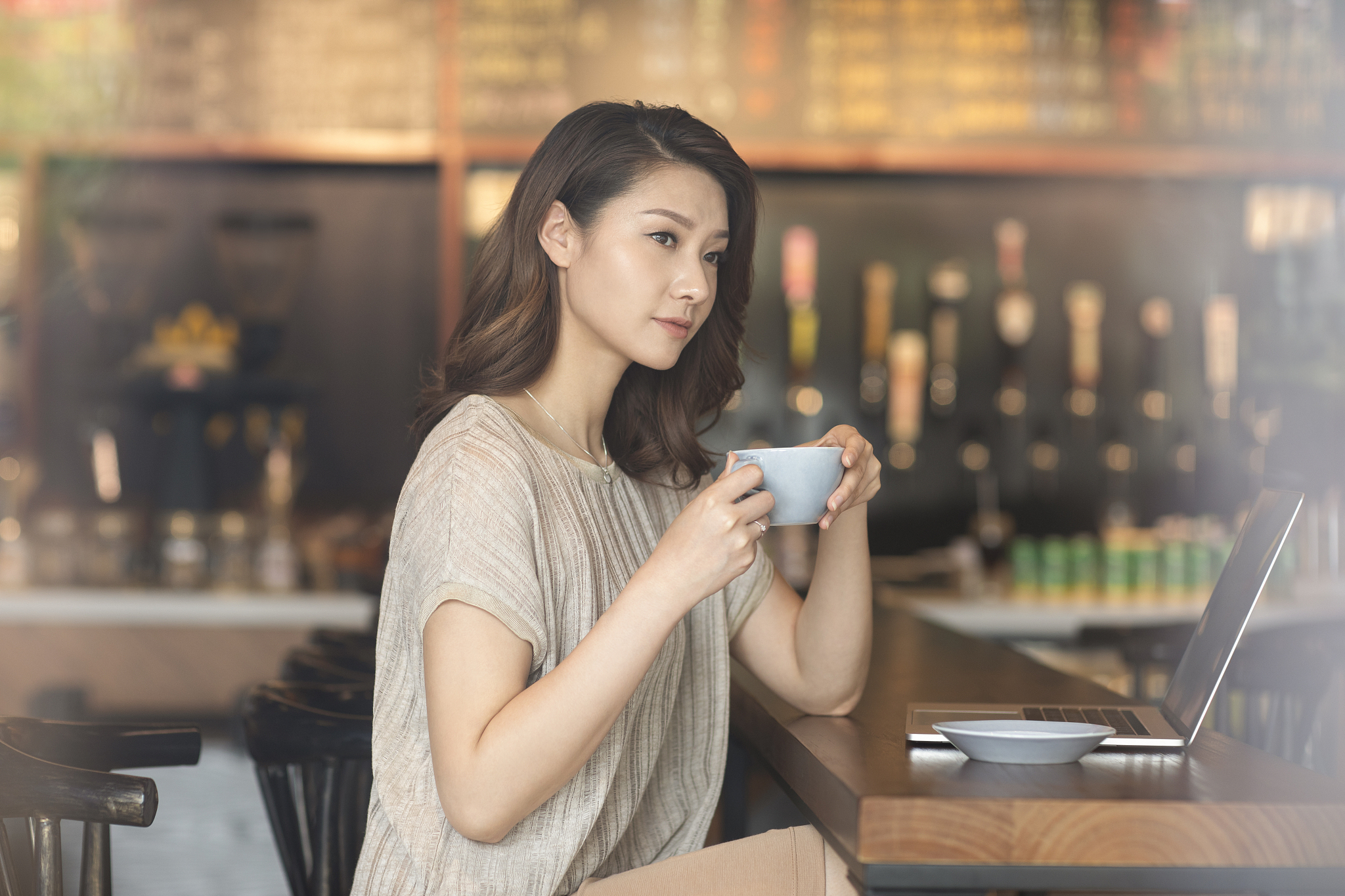 优雅女士在咖啡店使用笔记本电脑