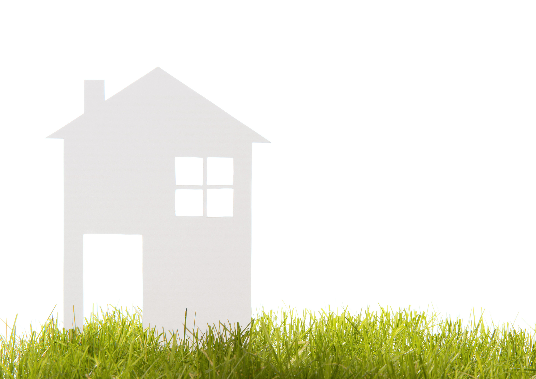 house cut out of paper on the grass