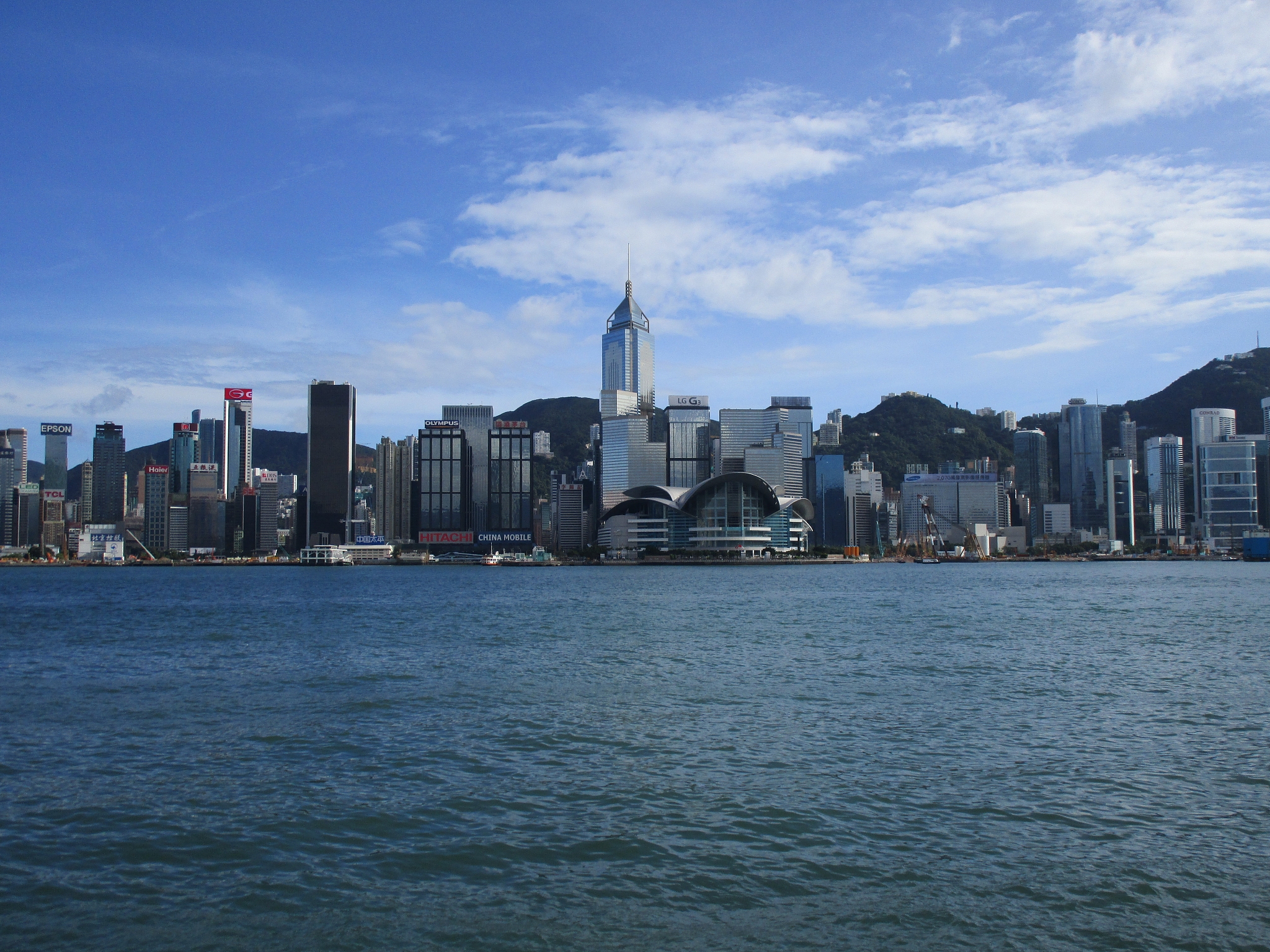 view of city at waterfront against cloudy sky