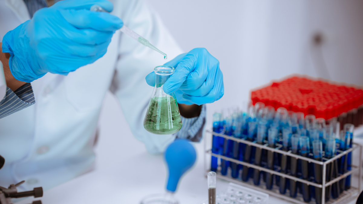 科学:医生在实验室里拿起试管进行分析,技术人员穿着