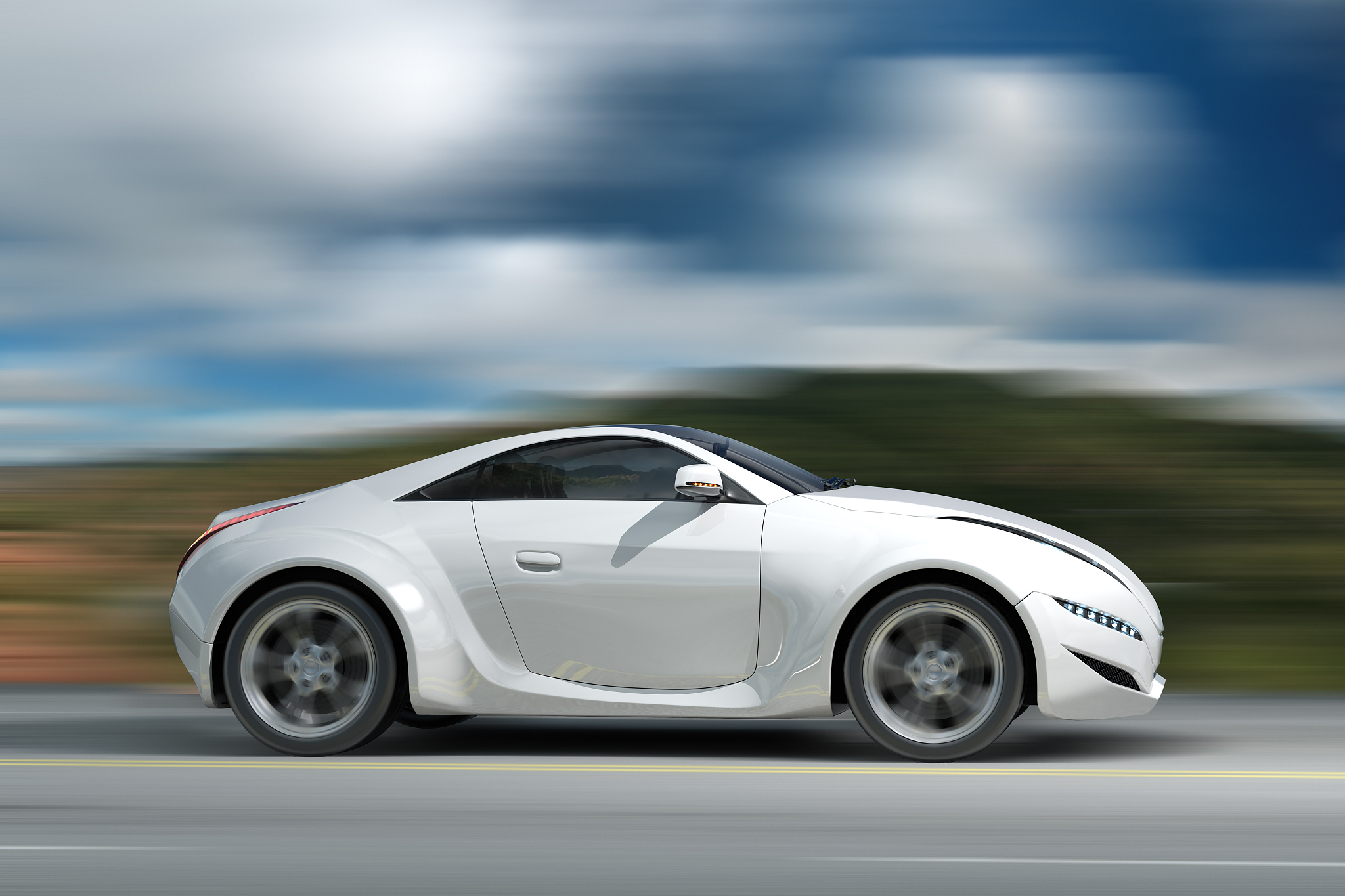 a blurred motion image of white coupe sports car driving by