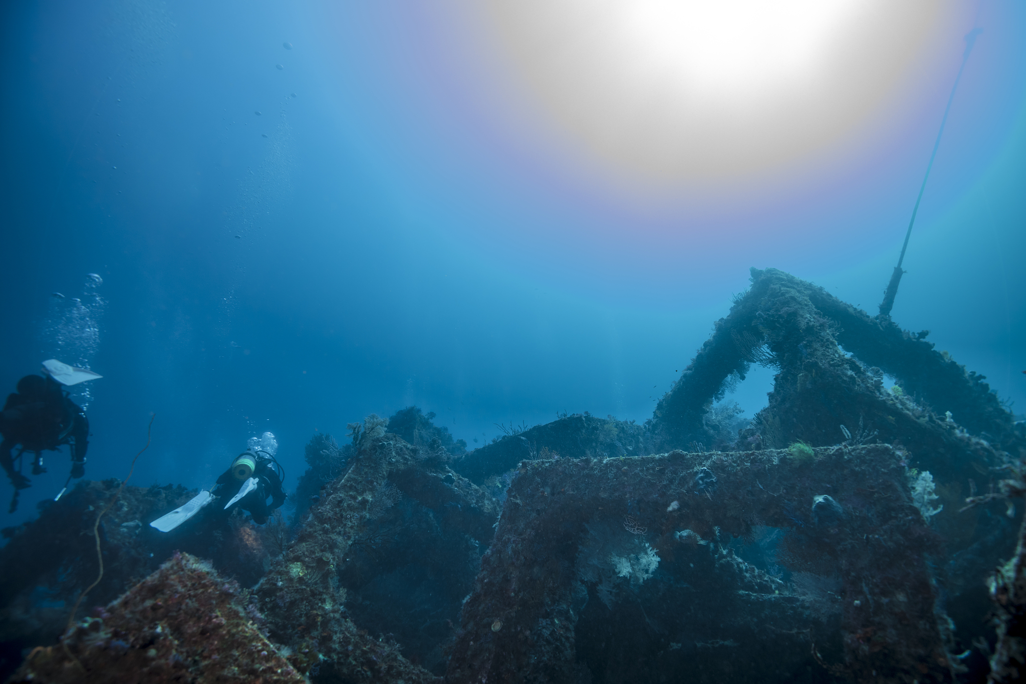 scuba divers swimming over the artificial fish reef