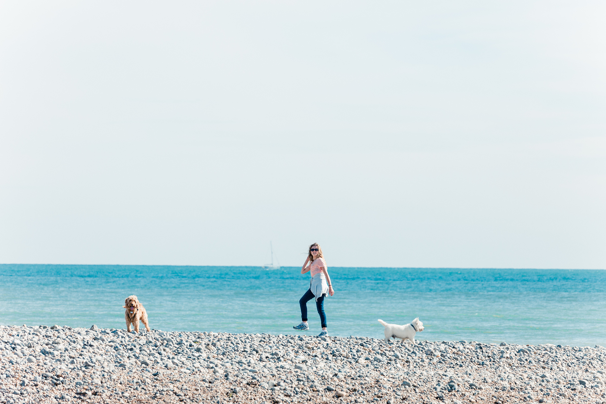 young woman walking the dogs by the sea