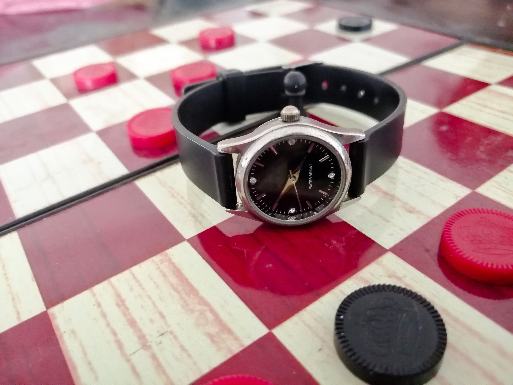 there is a ladies wrist watch on the chess board.