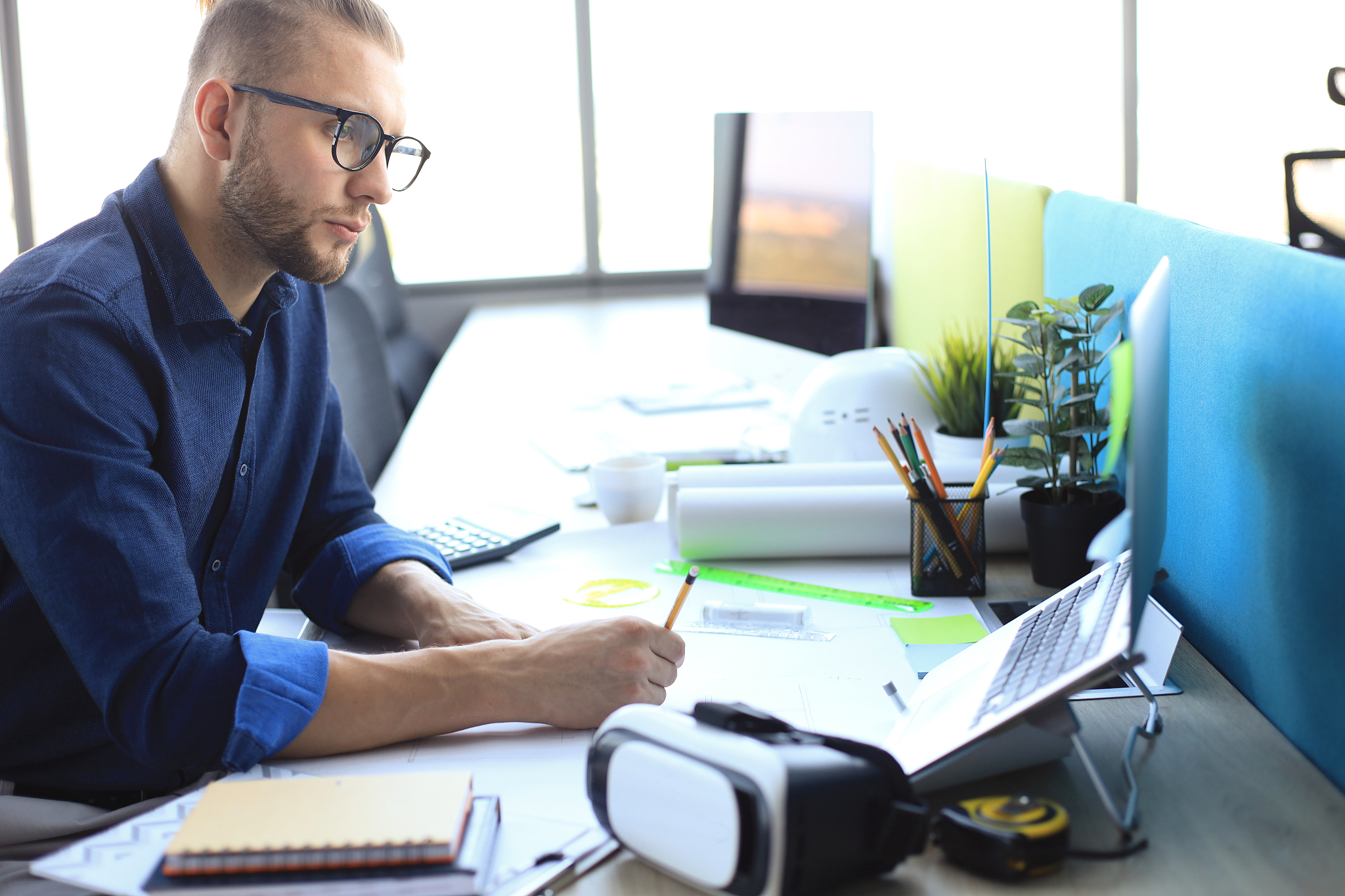 shot of a handsome male architect working on a design in his off