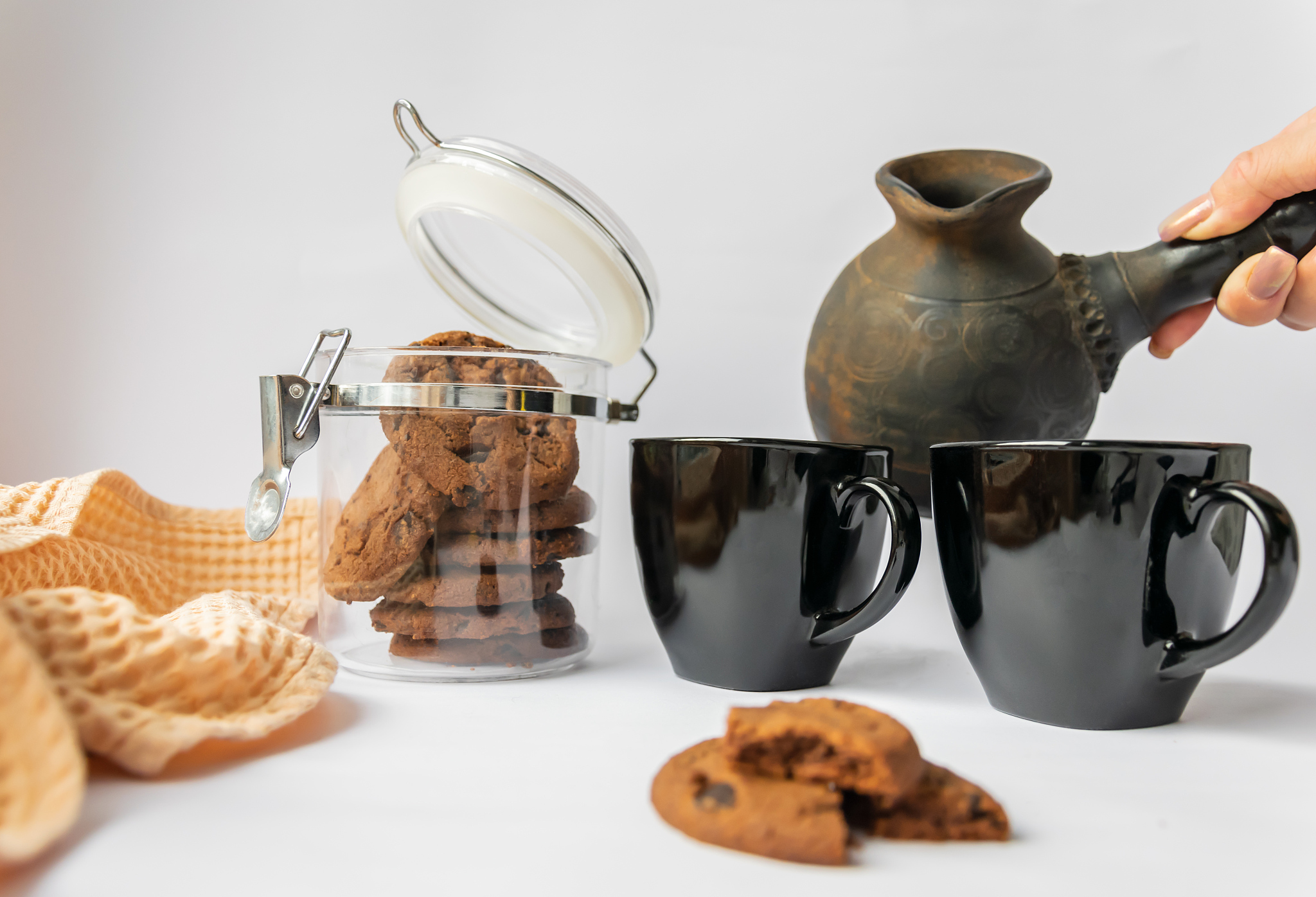 female hand is going to pour aromatic coffee from dark clay cezv