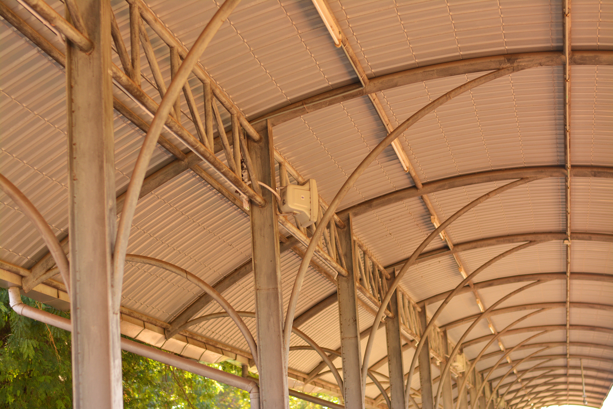 请将这段话竹框架构成了屋顶的结构层层竹梁按照垂直和对角线方向排列角度得当。为了加强建筑的短边方向和楼梯的支撑支撑梁上下两端再加入构造绑扎起来框架上表面再附加风撑。中间部分则架设一排竹椽支撑铁质波纹板屋面并覆盖木镶板高度调整到足够使用的水平。用另种方式描述可以改变语序使用修辞手法