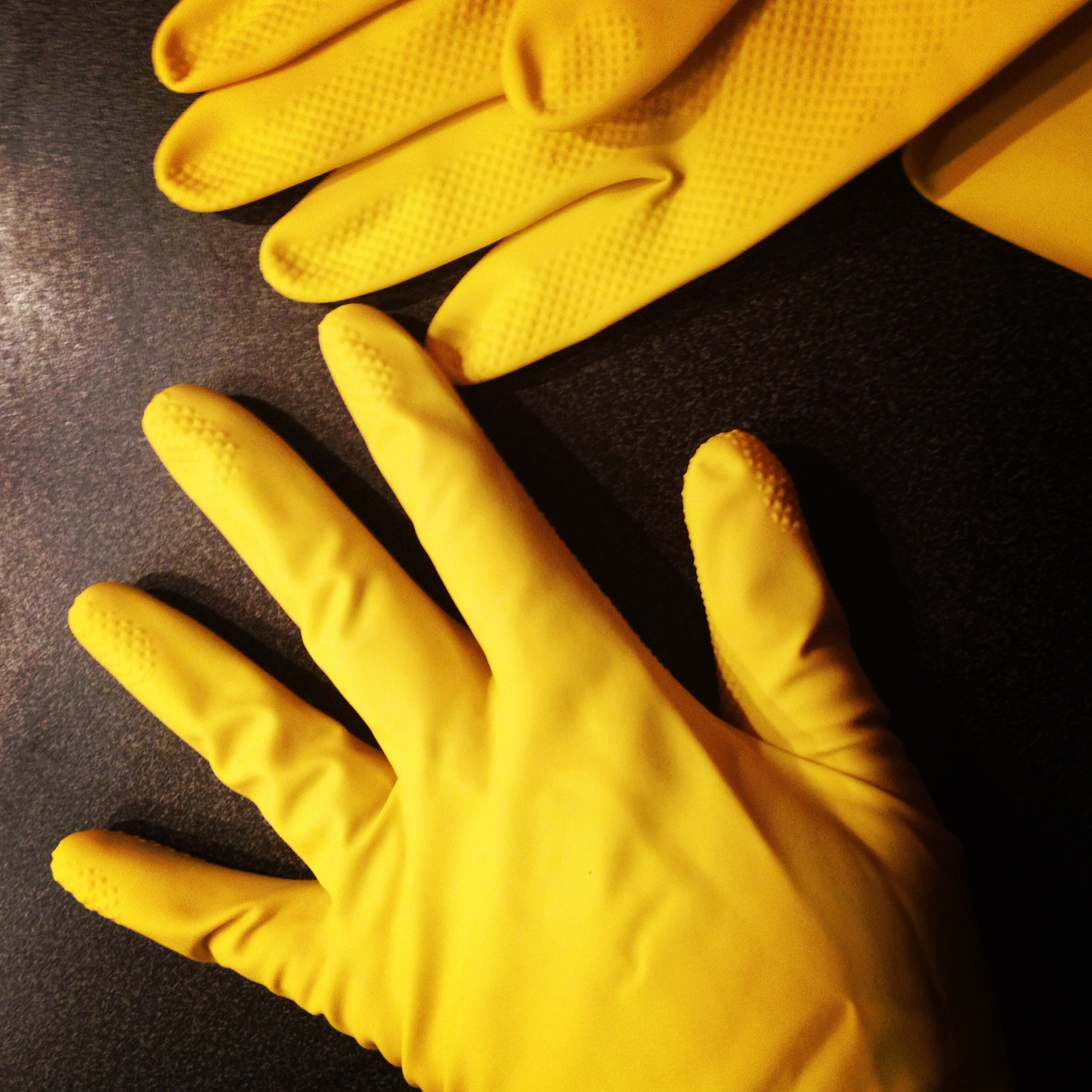 high angle view of yellow protective rubber gloves on table