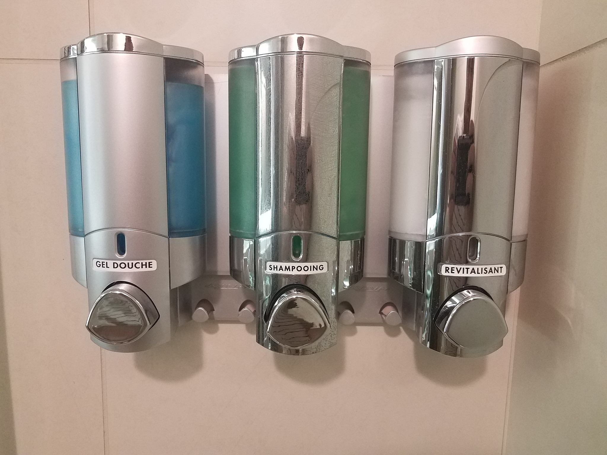 shower gel, shampoo, and conditioner in dispensers in french