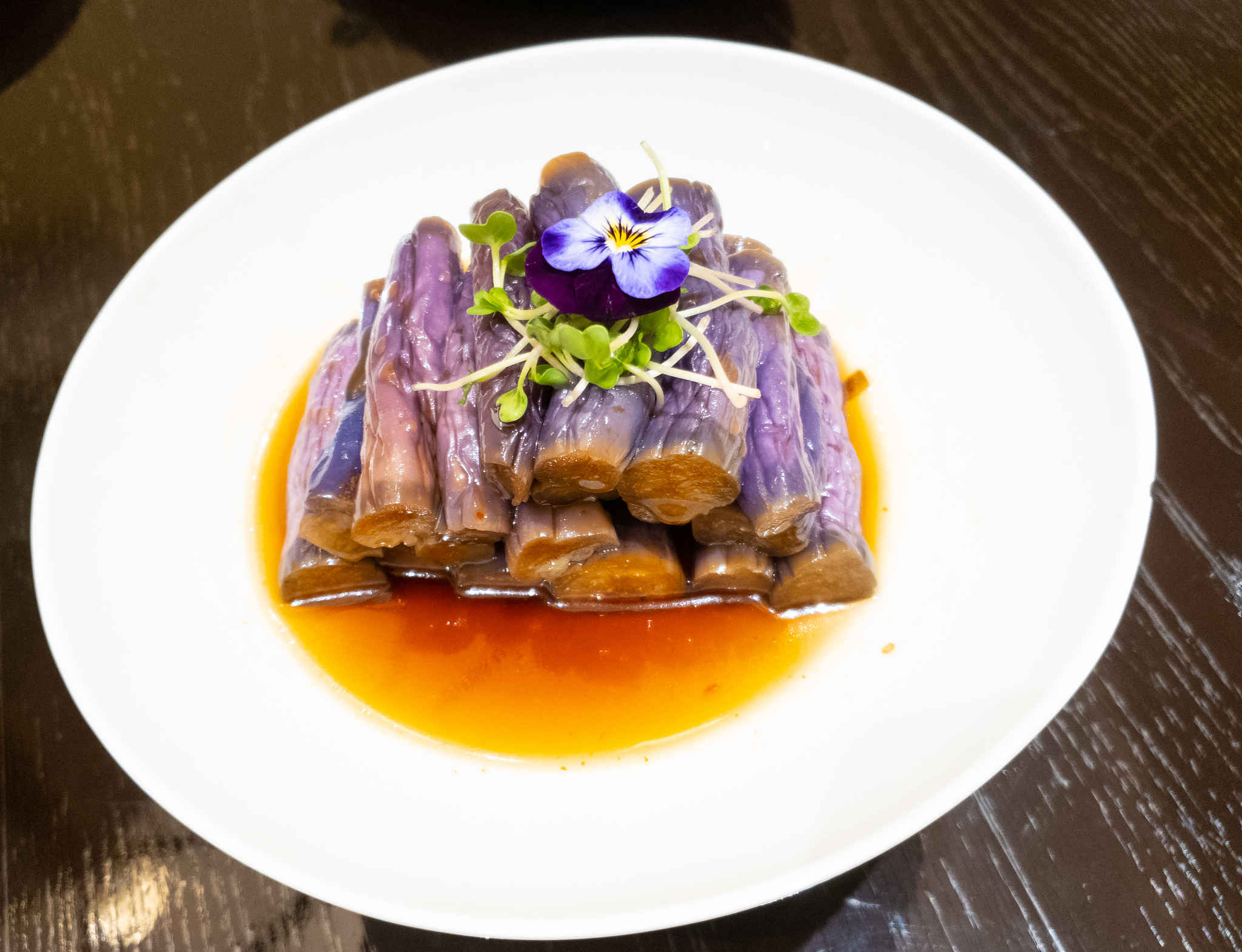 pickled purple eggplants with sauce on wood table