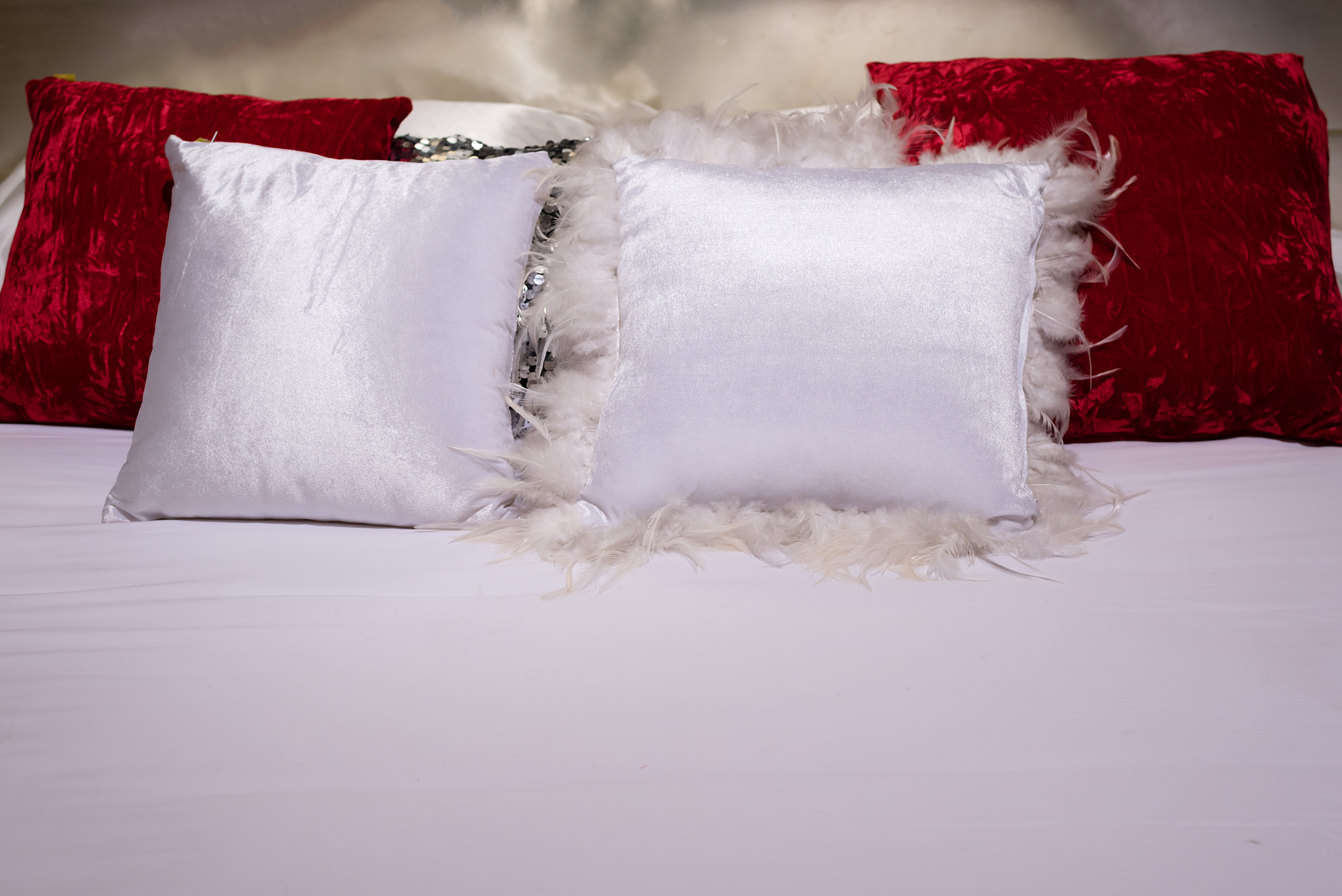 white fluffy pillow and red vevet pillow