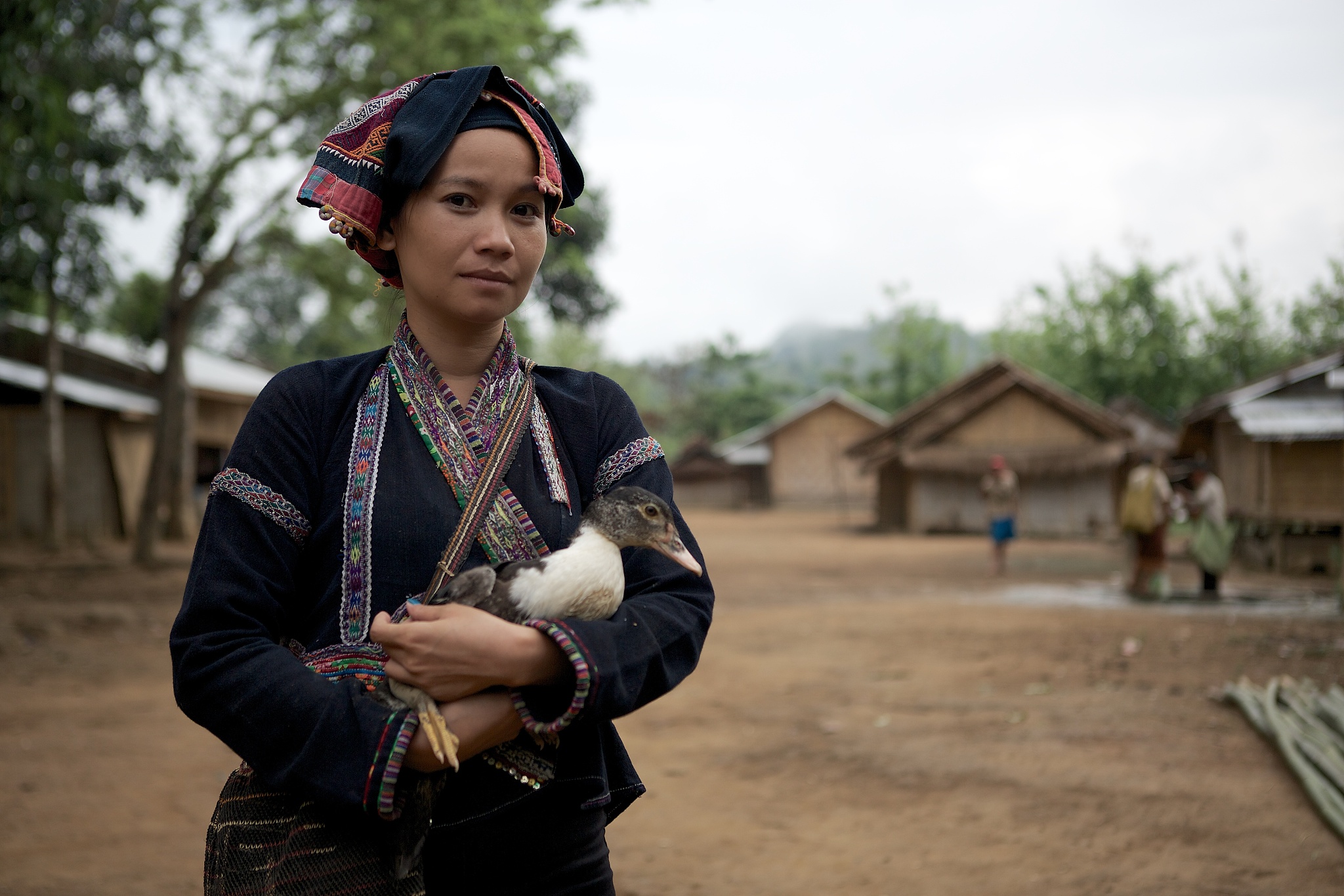 khmu woman in traditional dress holding a duck