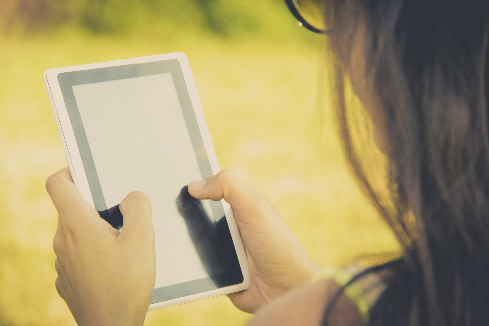 woman holds digital tablet, summer landscape