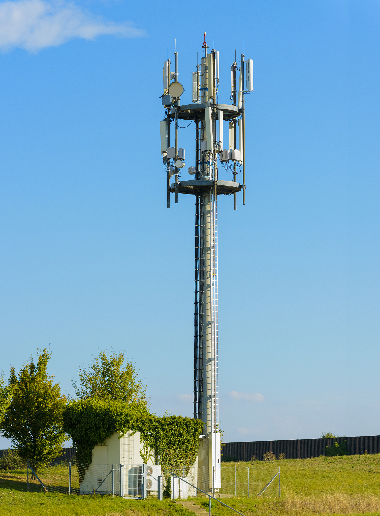 mobile phone antenna base station ground field close blue sky