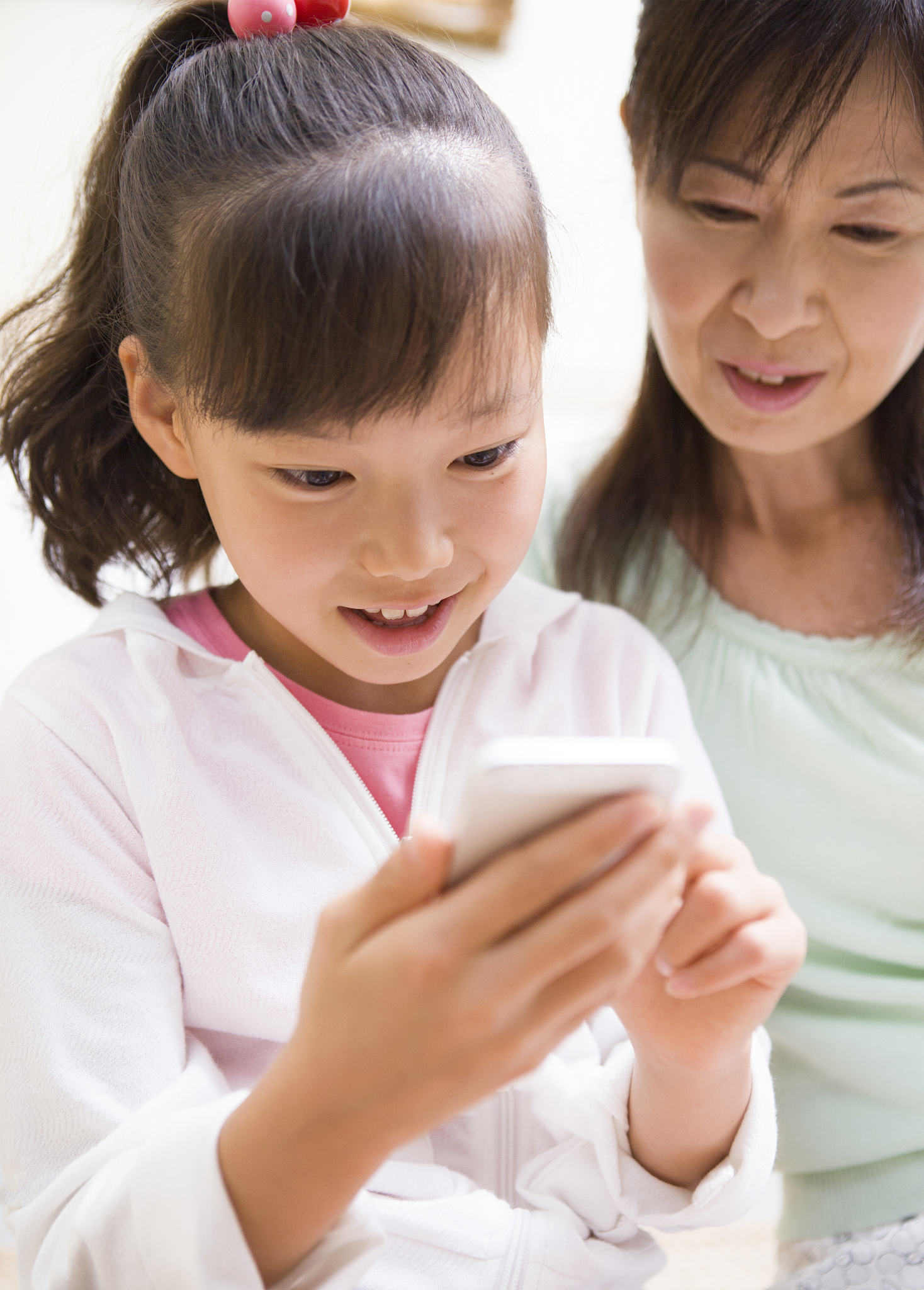 a girl and grandma using smartphone with a smile