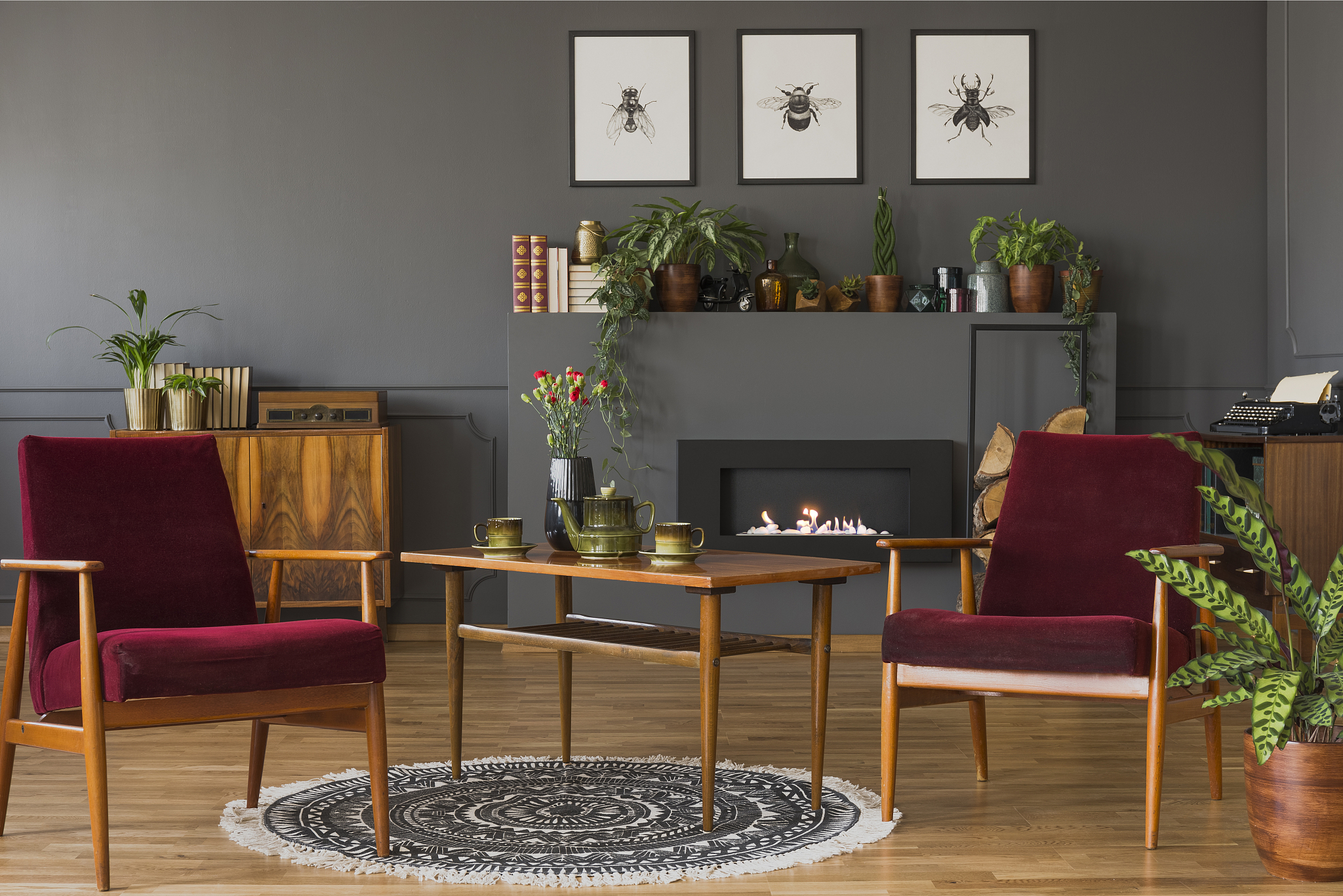 dark red wooden armchairs in vintage flat interior with posters 
