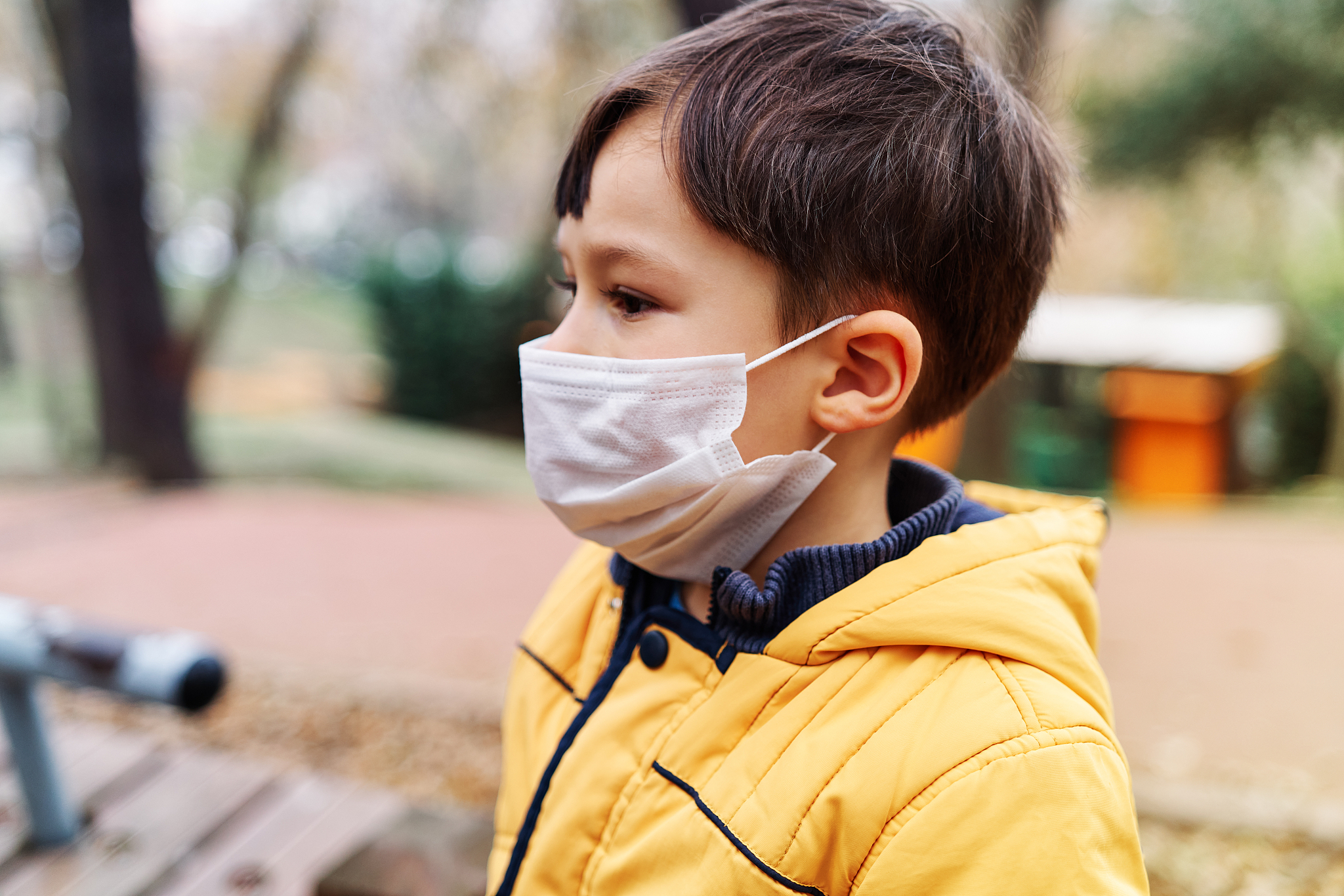 child on public park with surgical mask