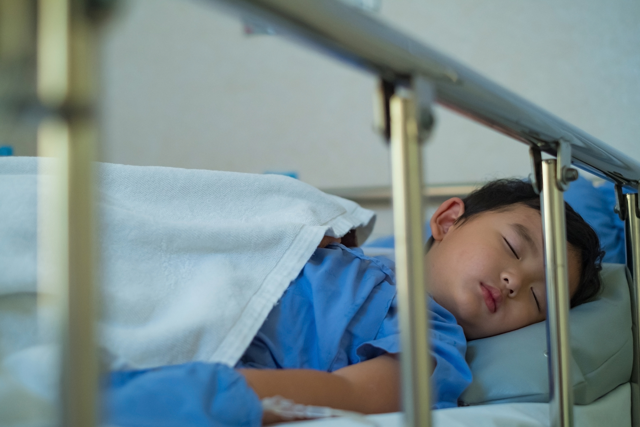 boy sleeping on bed in hospital