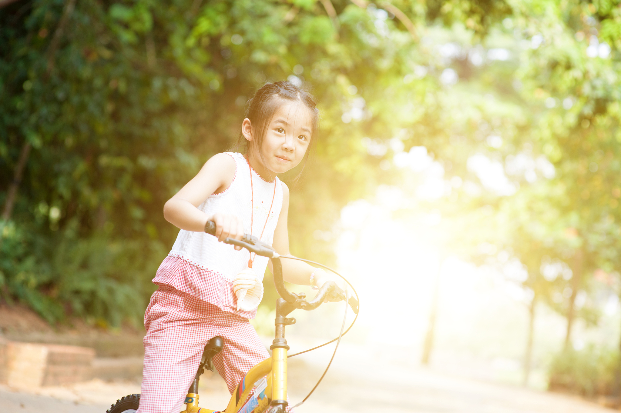 asian child riding bicycle outdoor.