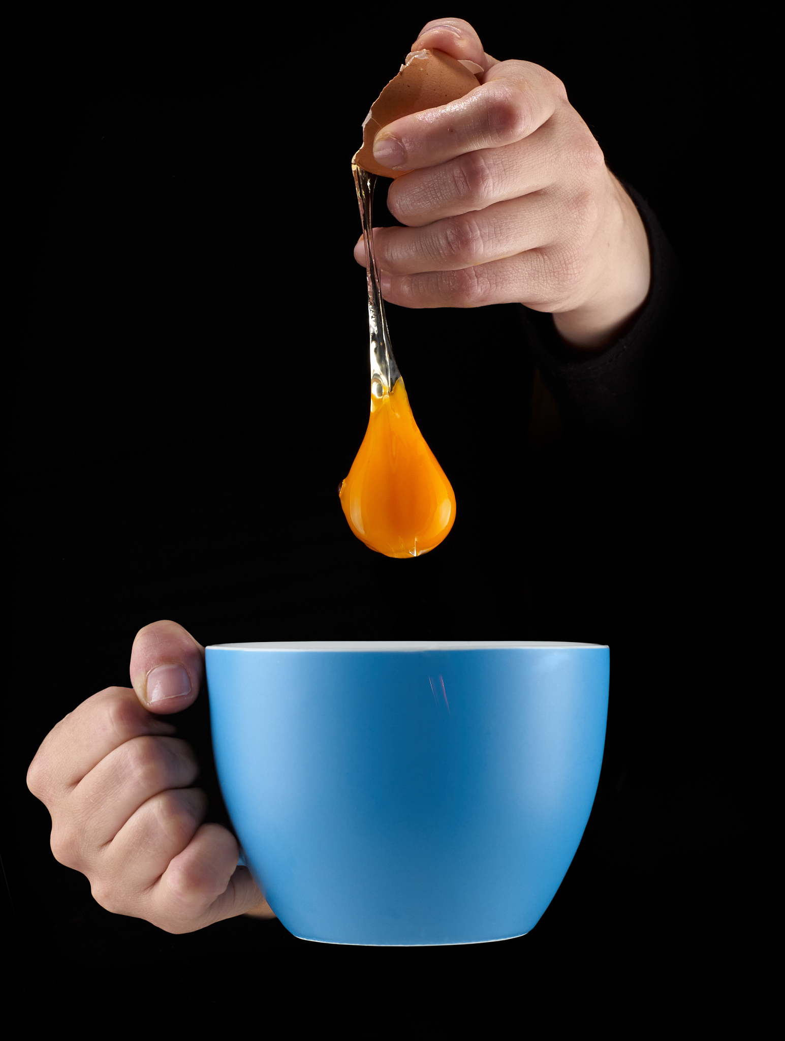 egg yolk dripping in to cup.