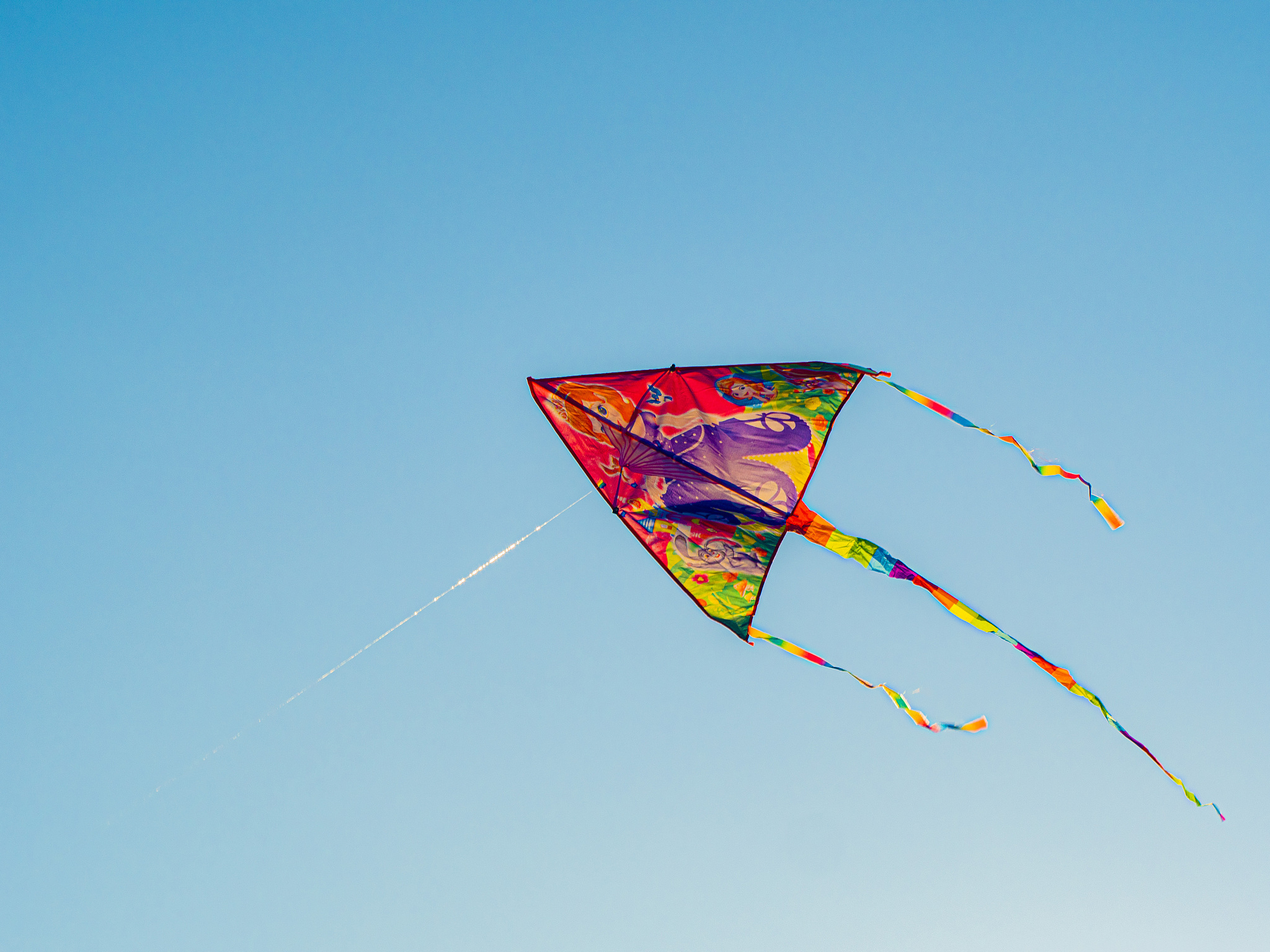 colorful cite flying in the wind blue sky. flying a kite up high