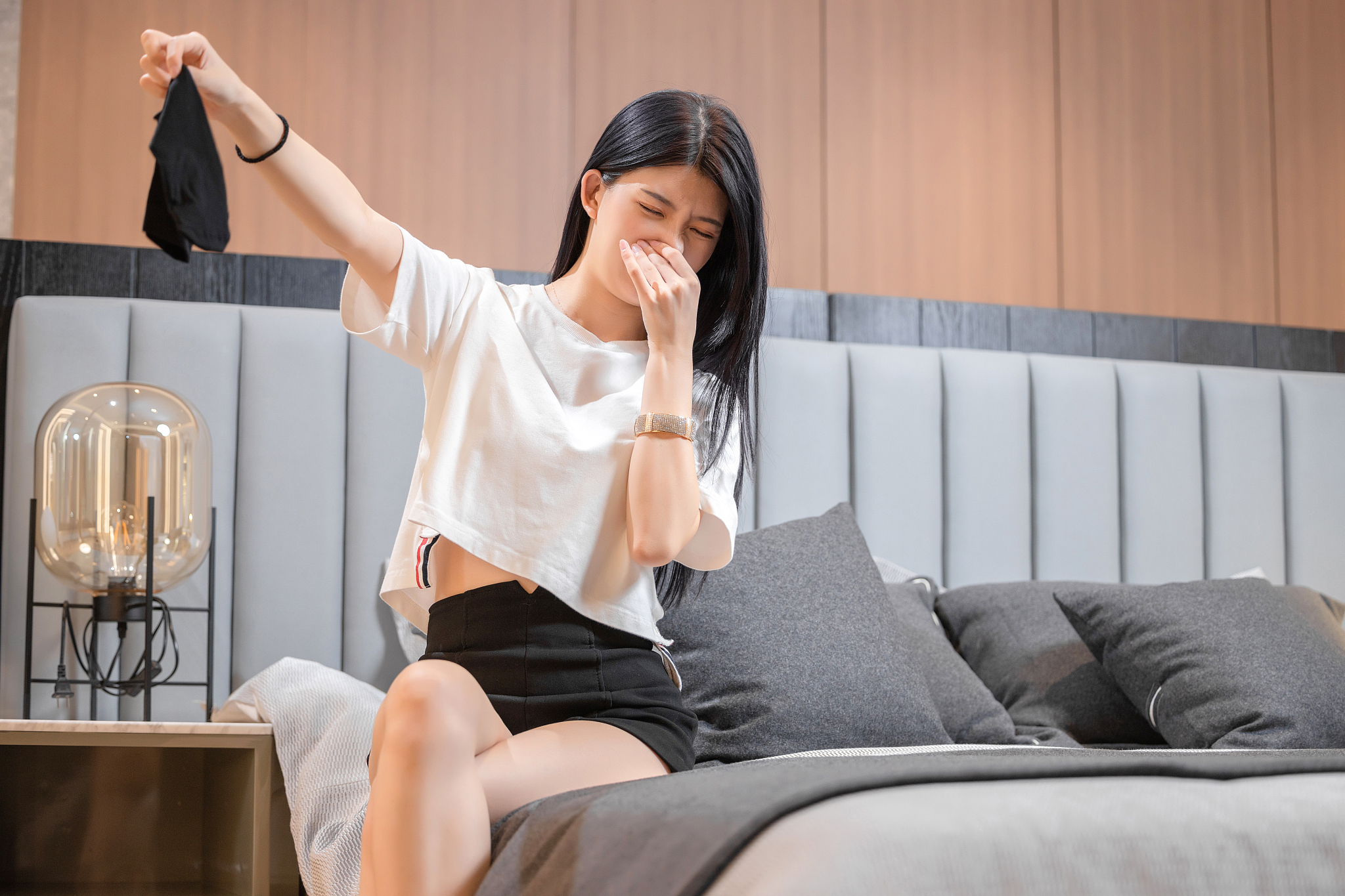 坐在床上,<strong>感觉</strong>衣服有异味的亚洲女孩