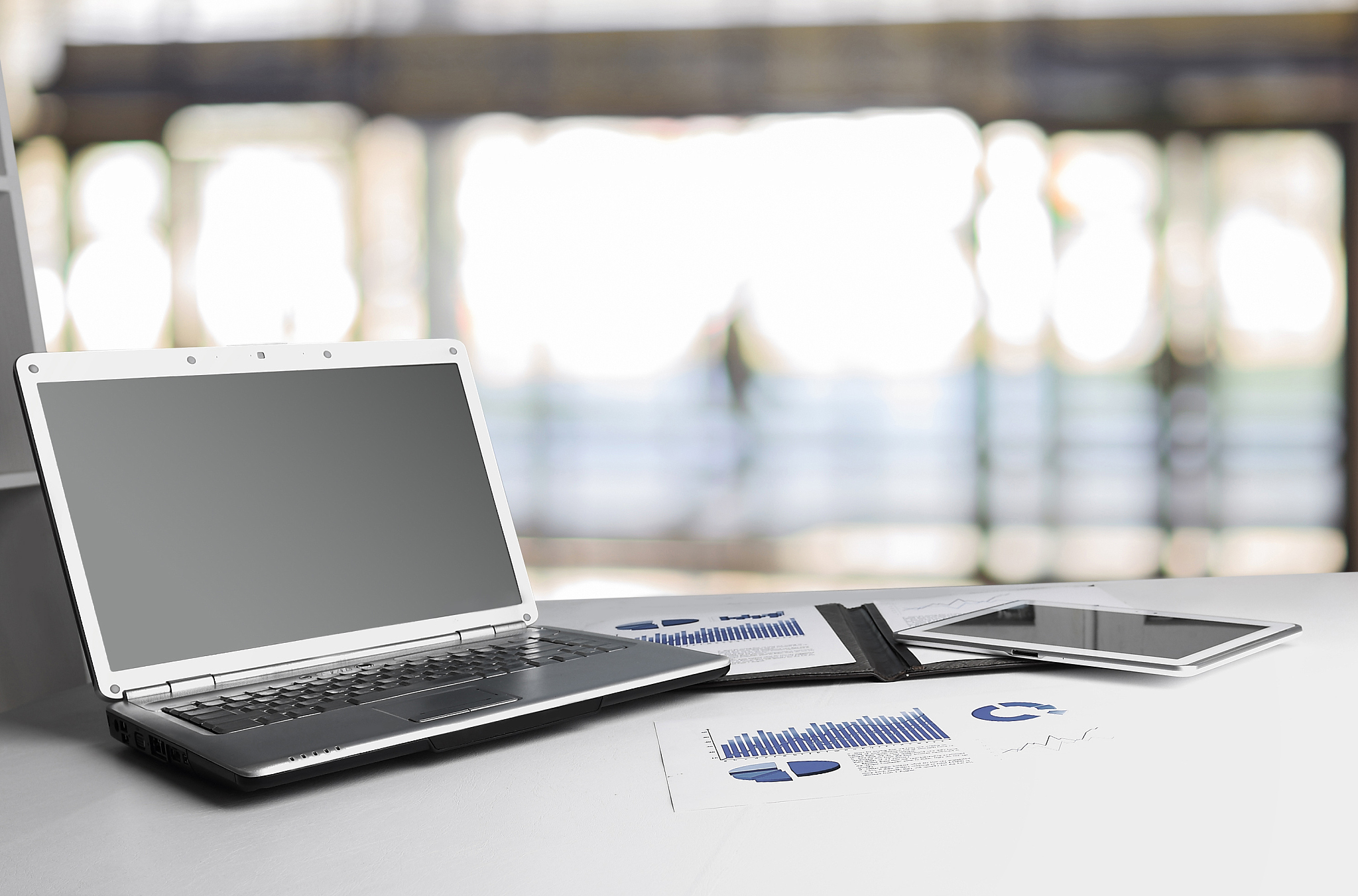 financial chart, laptop and tablet on the workplace of a busines