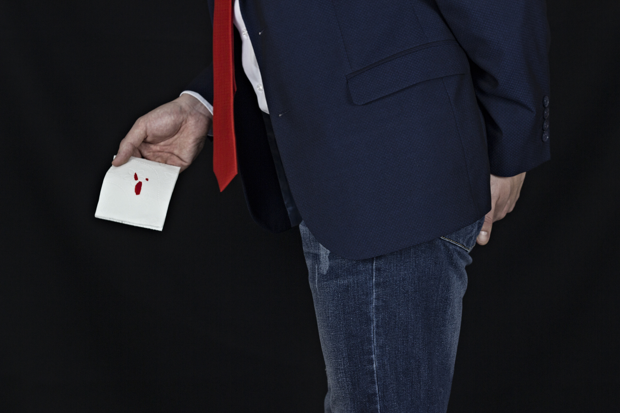 man in suit holds toilet paper with blood, hemorrhoids, black ba