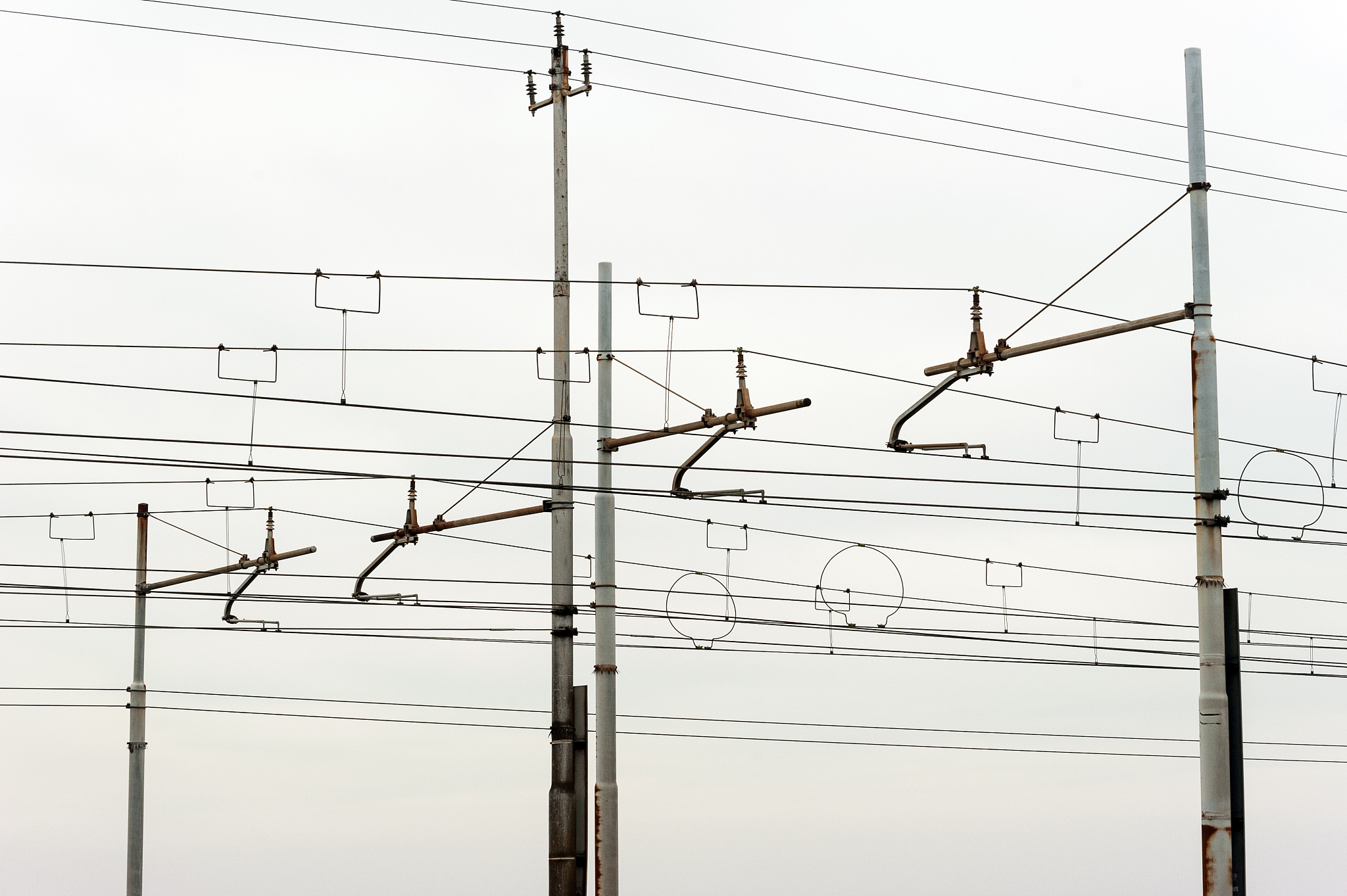 railway power lines on white sky