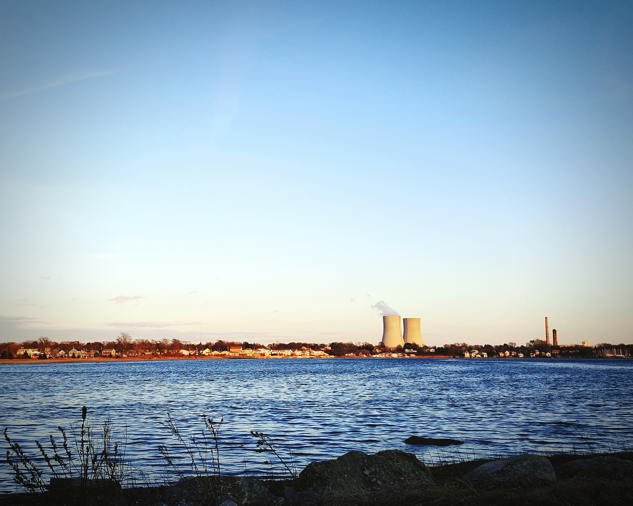 industry in front of river against clear sky on sunny day