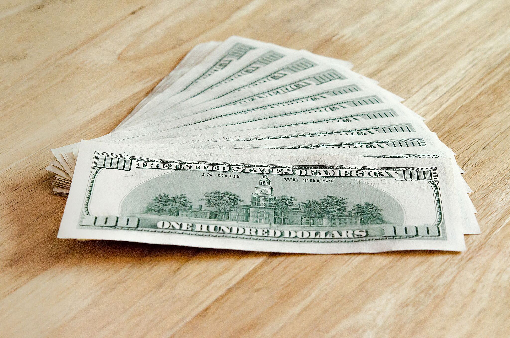 stack backside of  one hundred dollar bills