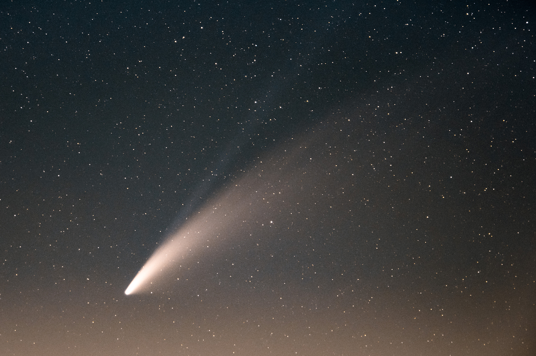 neowise comet and its long dust tail after dusk from etna volcan